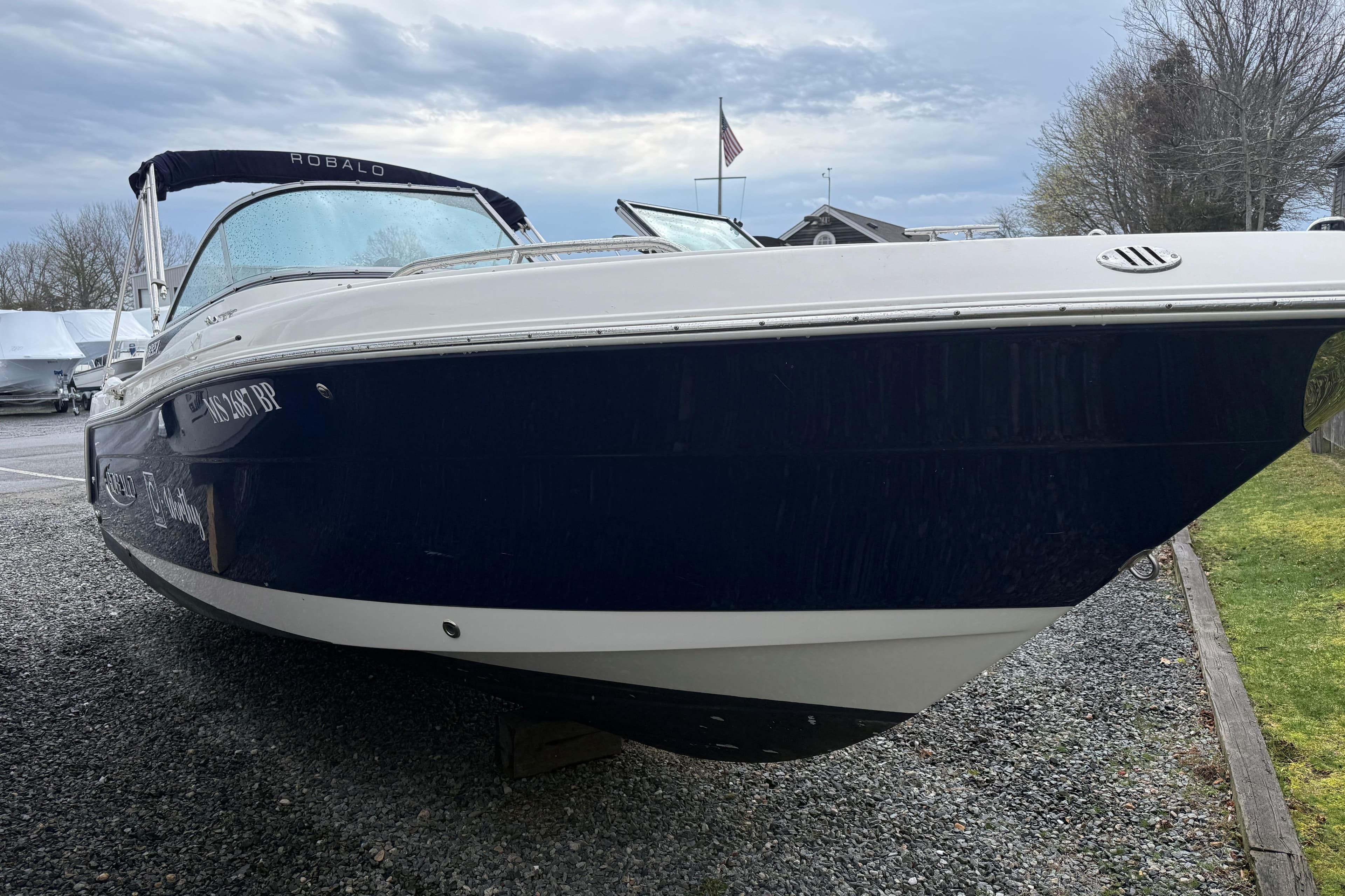 2021 Robalo R227 Dual Console boat on gravel, under cloudy sky.