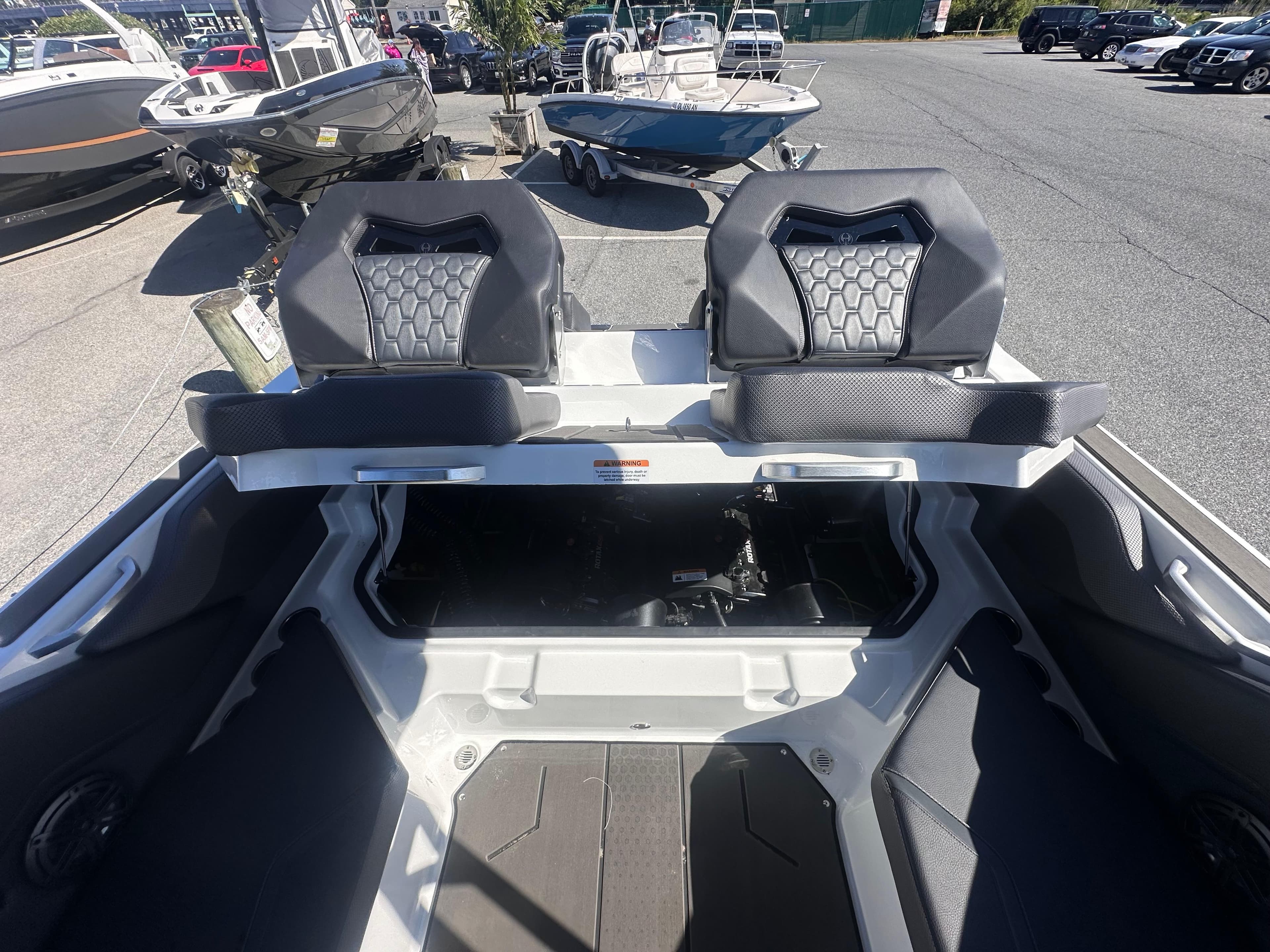 2025 Scarab 235 LX boat interior with dual seats and open storage compartment.