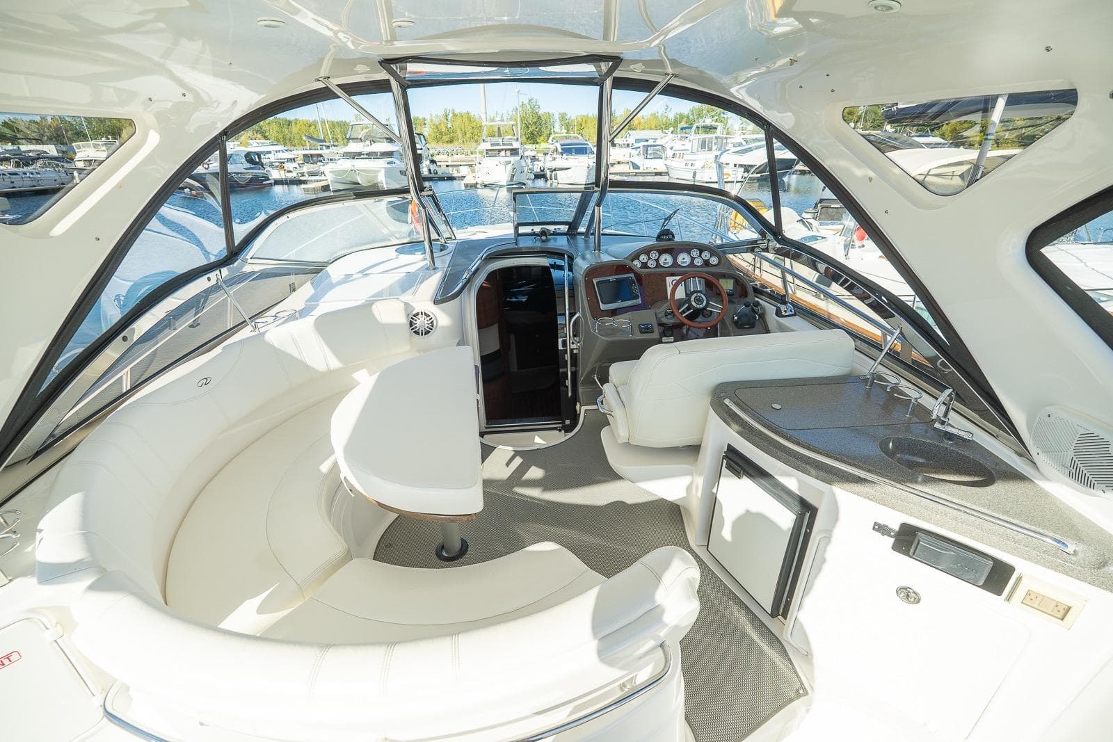 2009 Regal Commodore 4060 yacht interior with seating, helm, and kitchenette at marina.