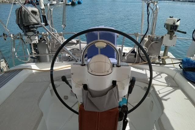 Cockpit of a 2005 Beneteau 393 sailboat with steering wheel and ocean view.