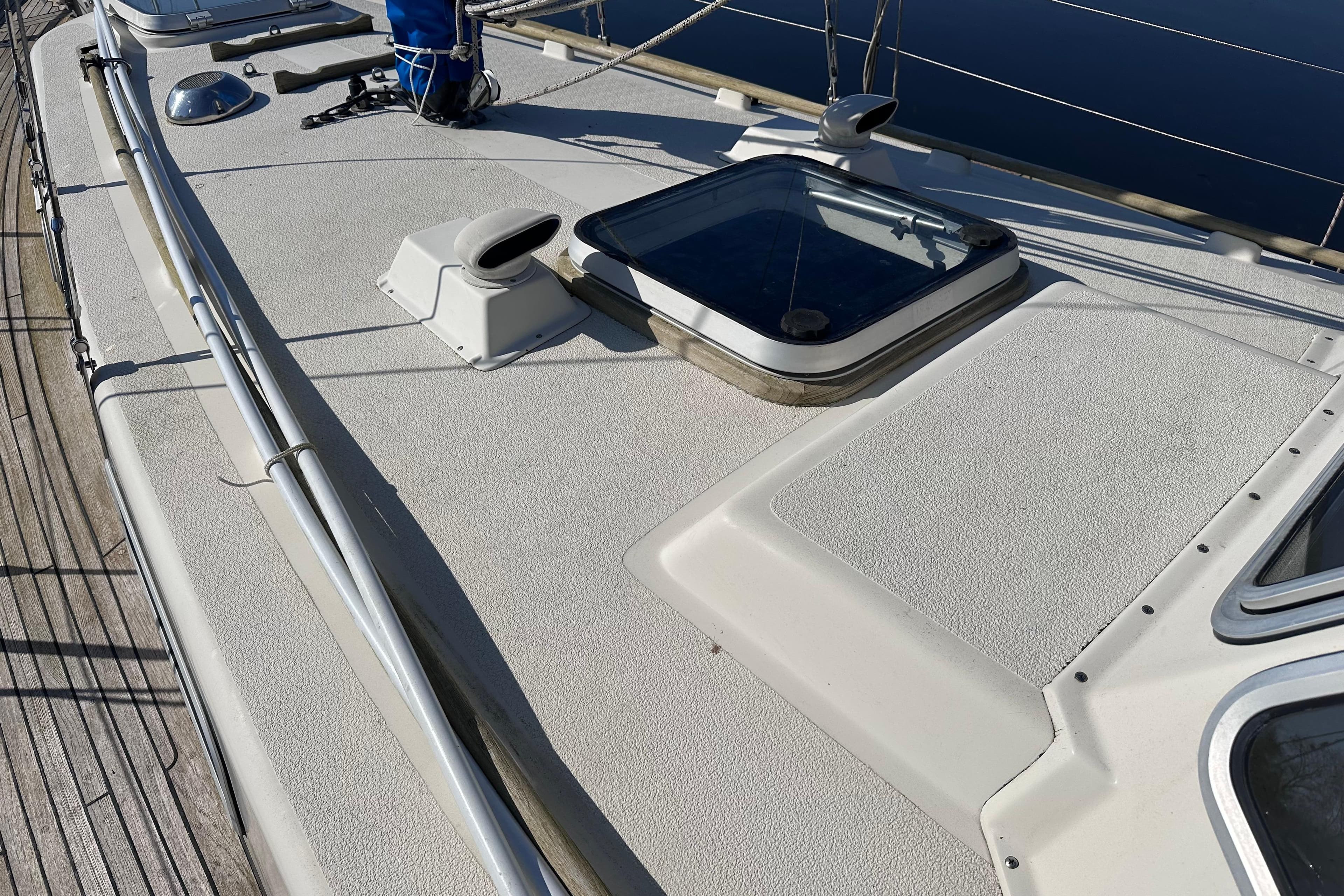Deck of 1987 Hallberg-Rassy 94 Kutter sailboat with hatch and railing.
