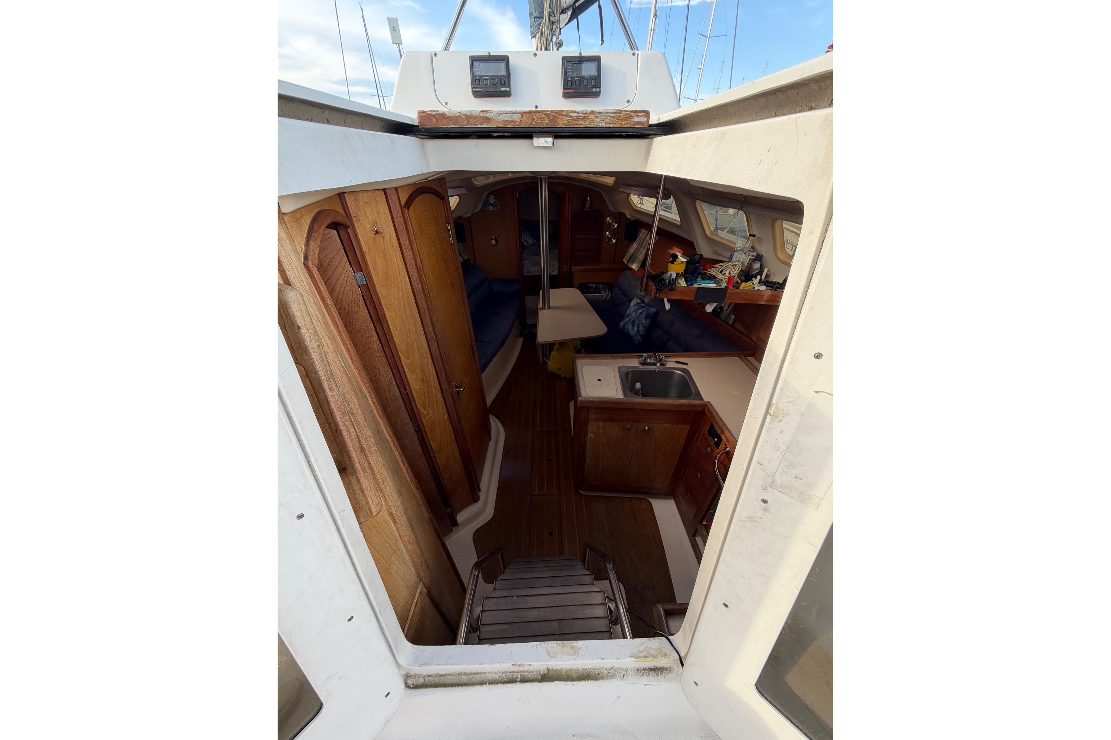Interior view of a 2000 Hunter 310 sailboat, featuring wooden cabinetry and compact kitchen area.