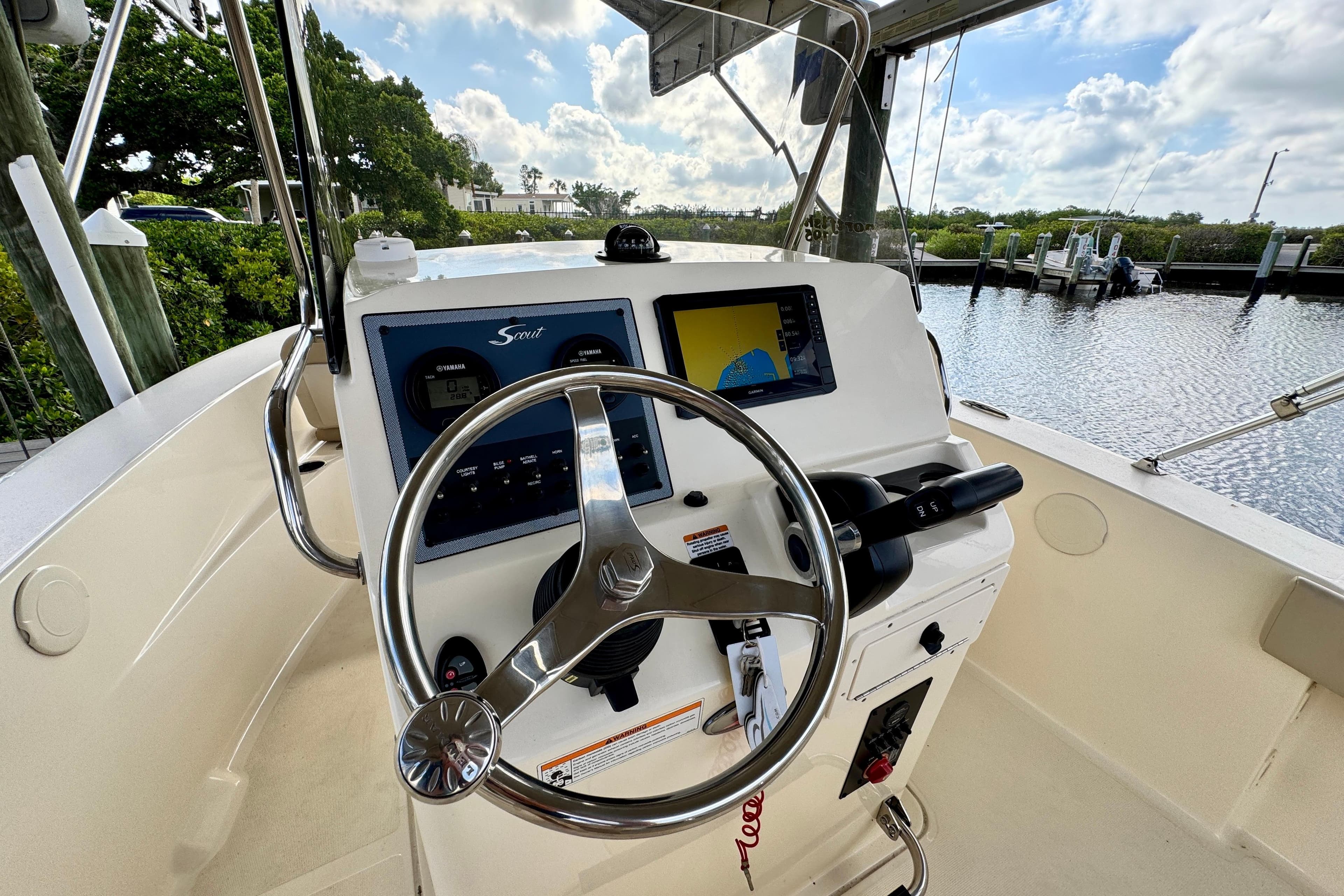 2024 Scout 195 Sportfish boat helm with steering wheel and navigation display.