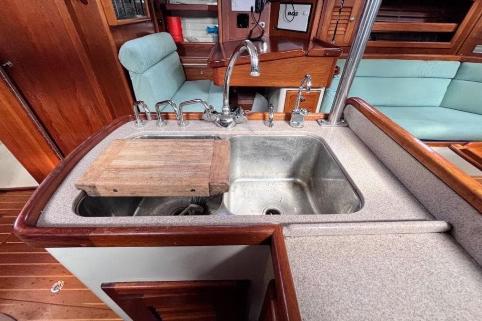 Galley sink area in 2002 Pacific Seacraft 40 yacht with wooden accents and seating.