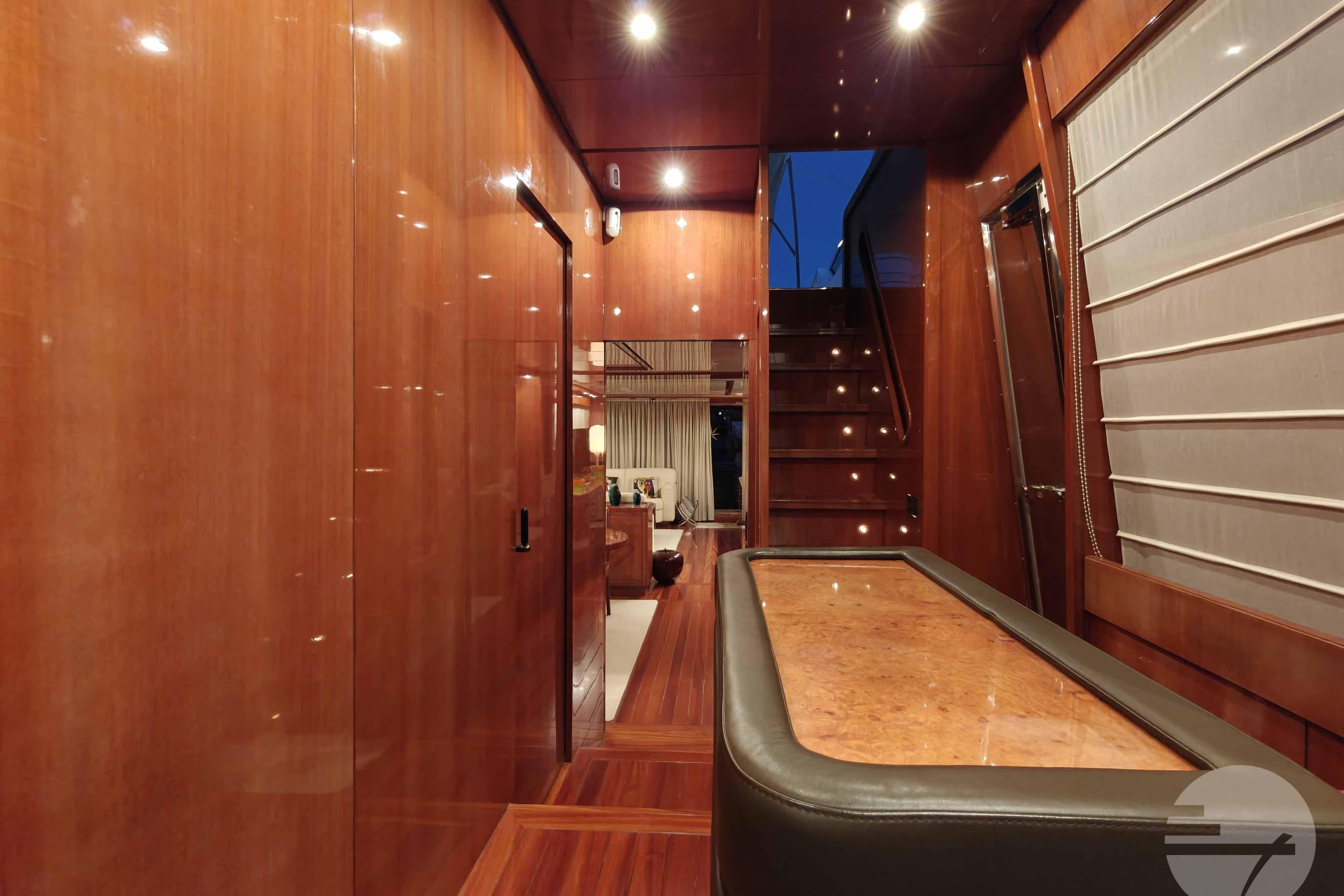 Luxurious interior of 1999 Sanlorenzo SL82 yacht with polished wood finishes and elegant lighting.