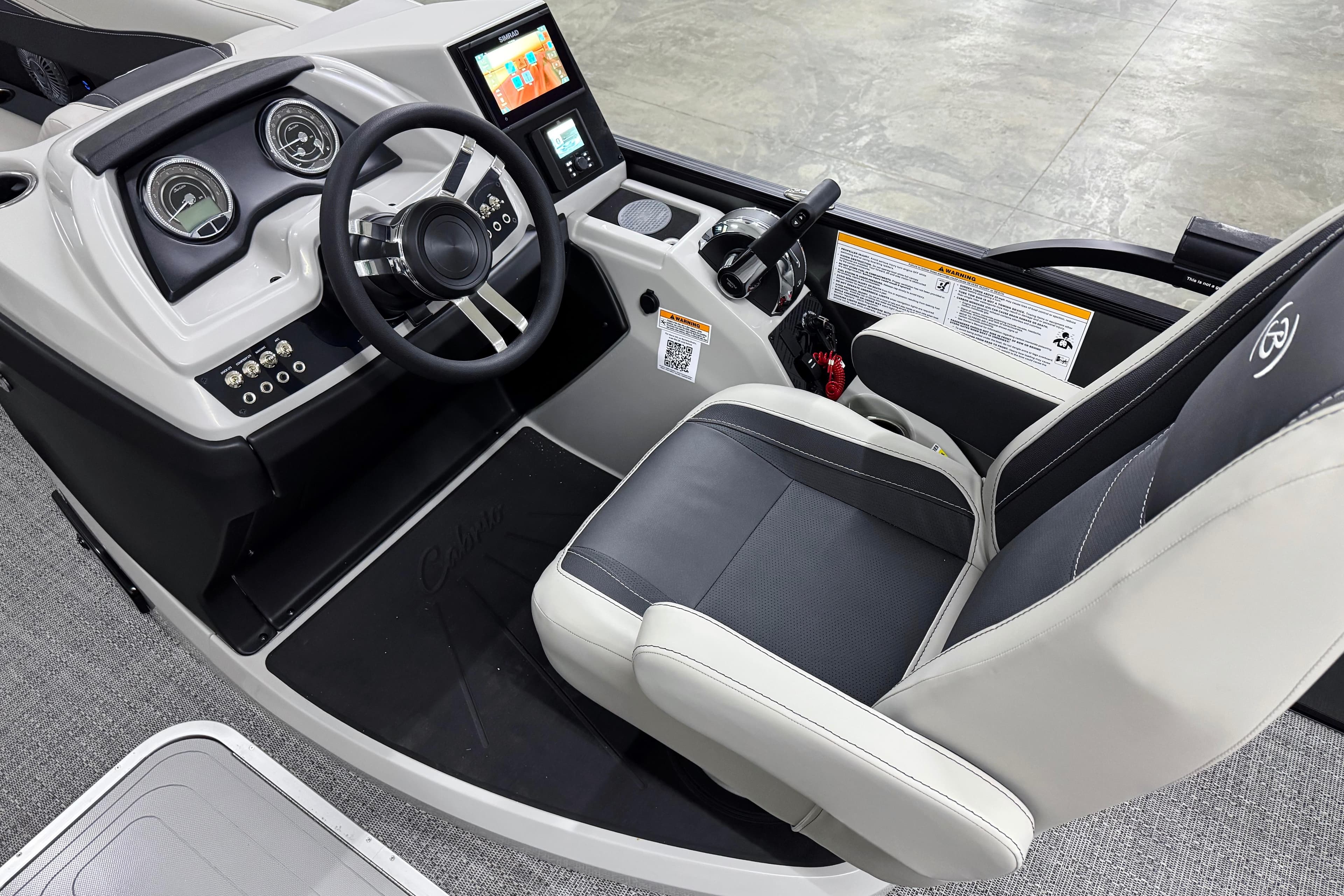 2026 Barletta Cabrio 24UC boat interior with steering wheel and dashboard controls.