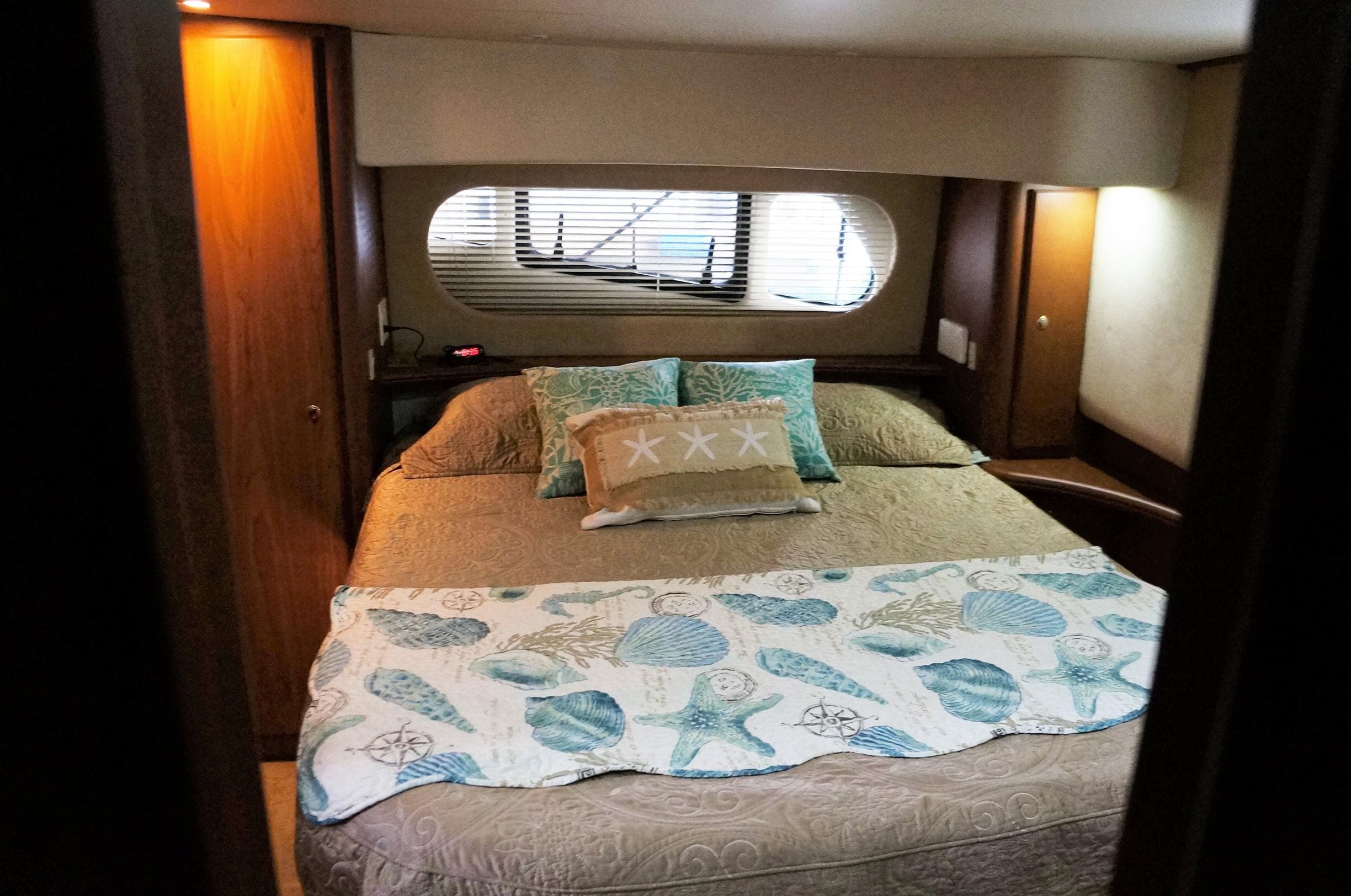 Interior of 2005 Silverton 39 Motor Yacht, cozy bedroom with nautical decor.