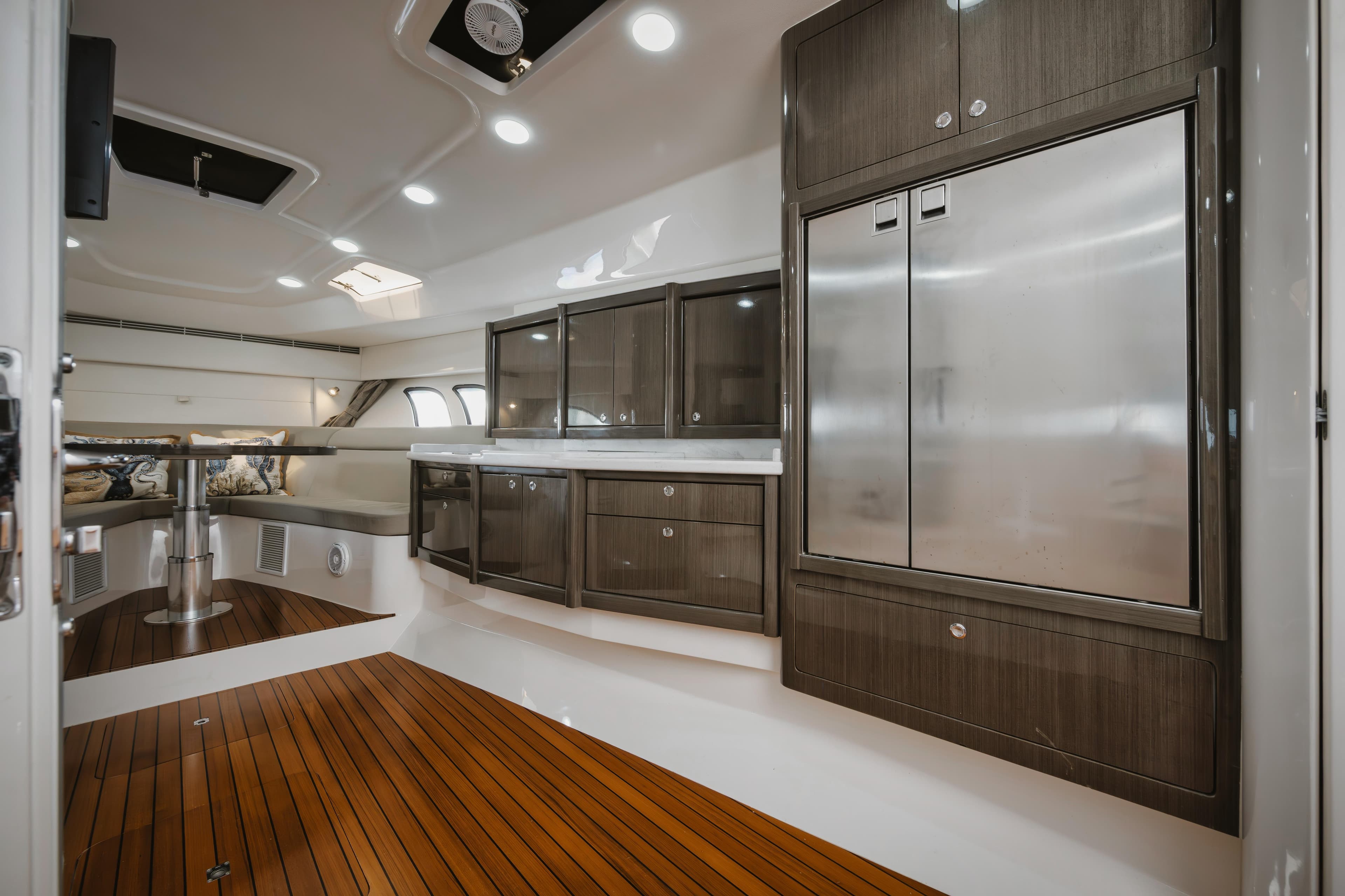 Luxurious interior of 2018 Intrepid 475 Sport Yacht with sleek cabinetry and wooden flooring.