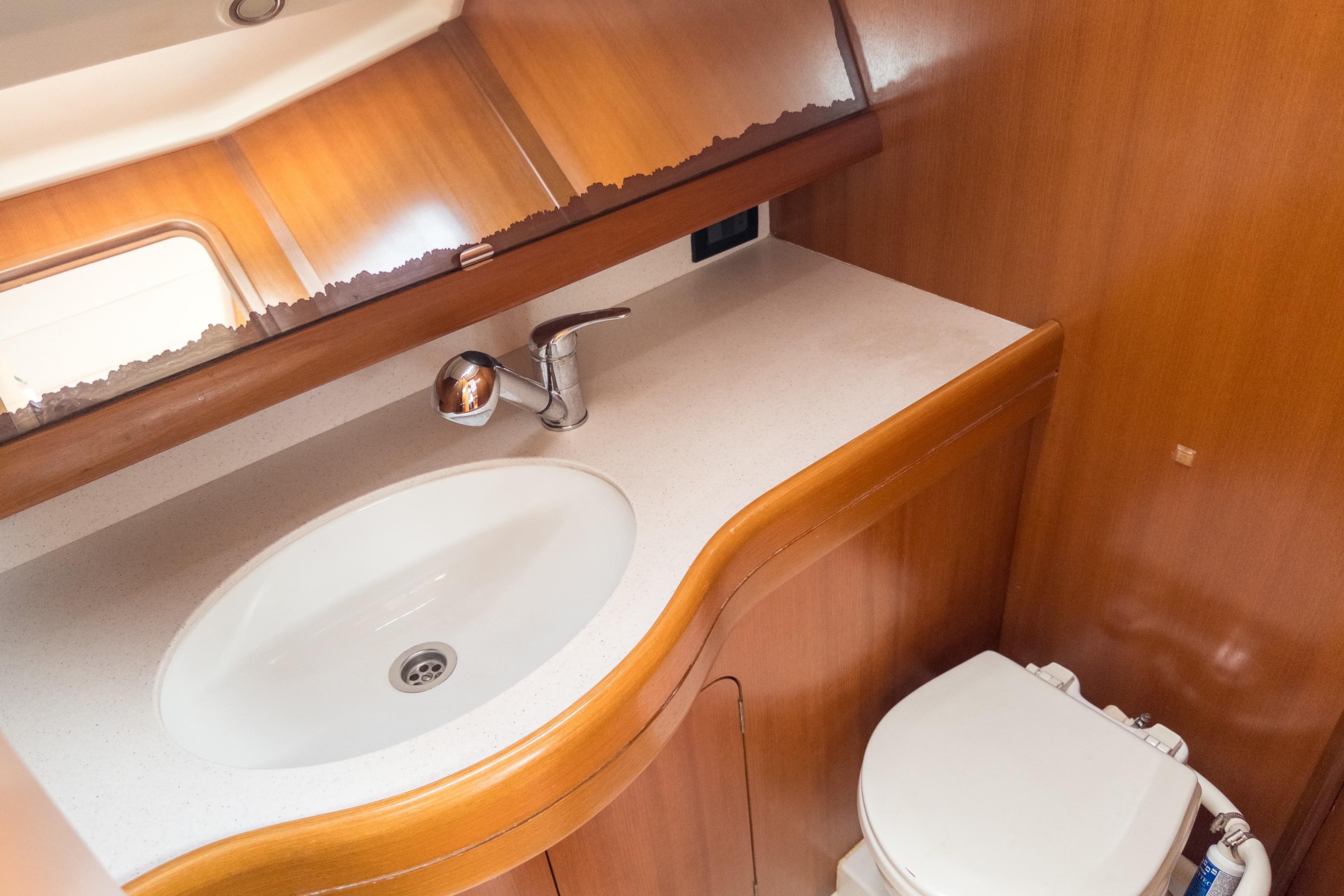 Luxurious bathroom in 2005 Grand Soleil 45 yacht with wooden cabinetry and modern fixtures.