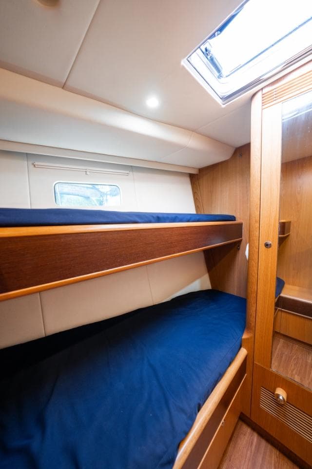 Bunk beds in 2014 Discovery 57 yacht cabin with wooden interior and skylight.