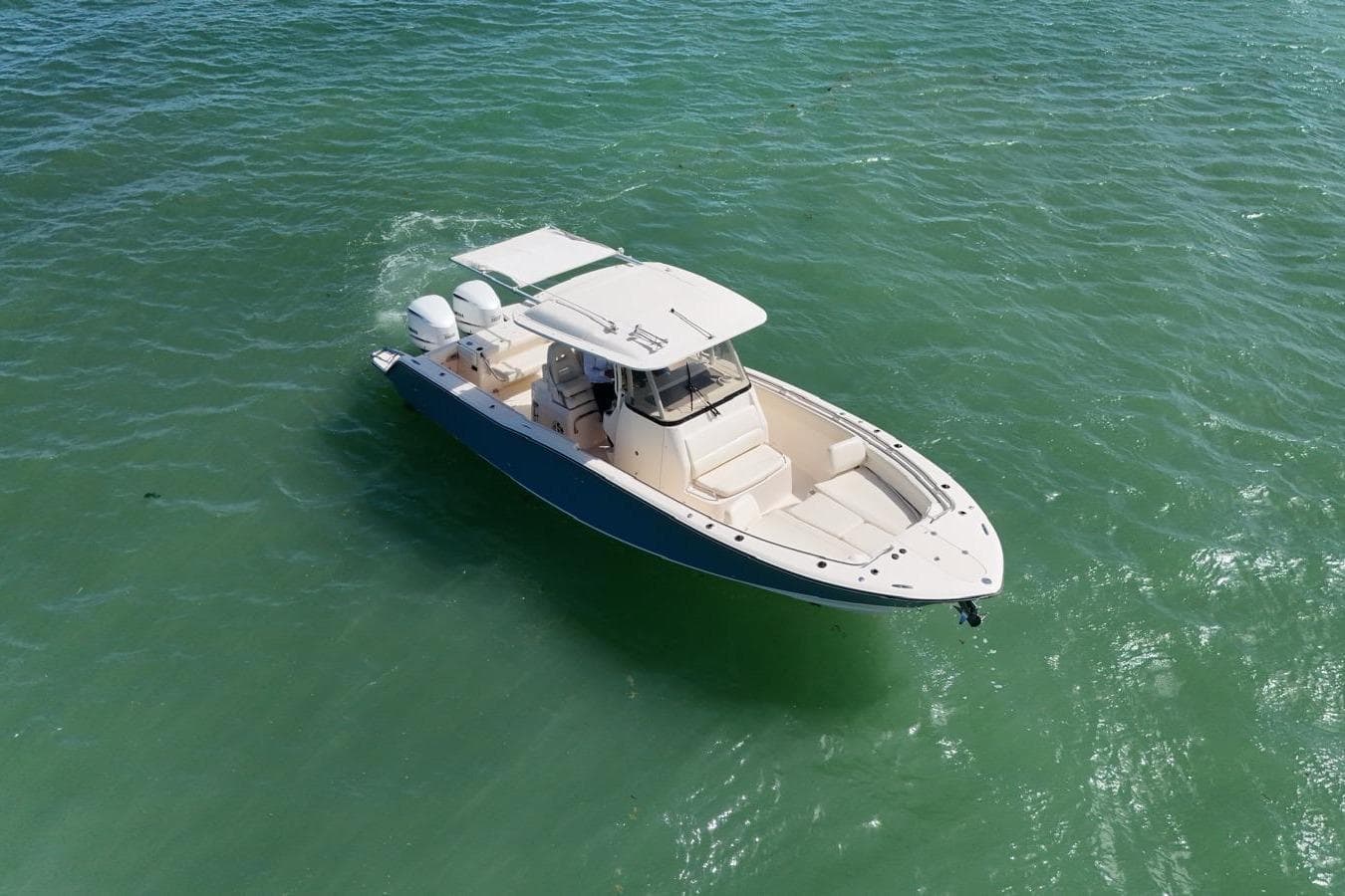 2021 Grady-White Canyon 326 boat cruising on clear green water.
