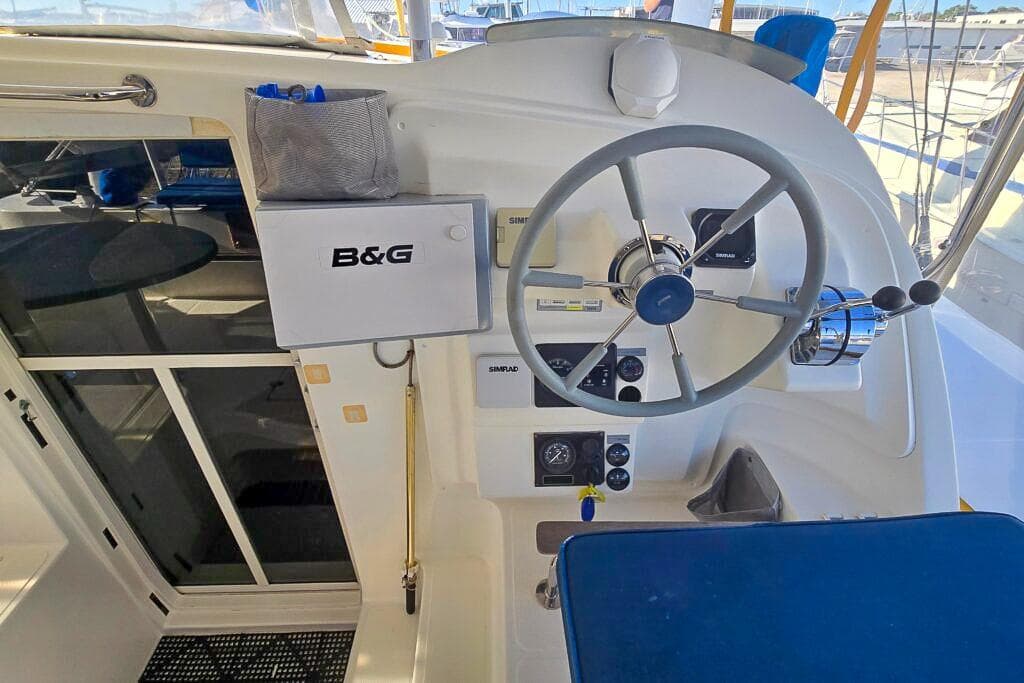 Helm of 2006 Dolphin 460 yacht with steering wheel and navigation equipment.