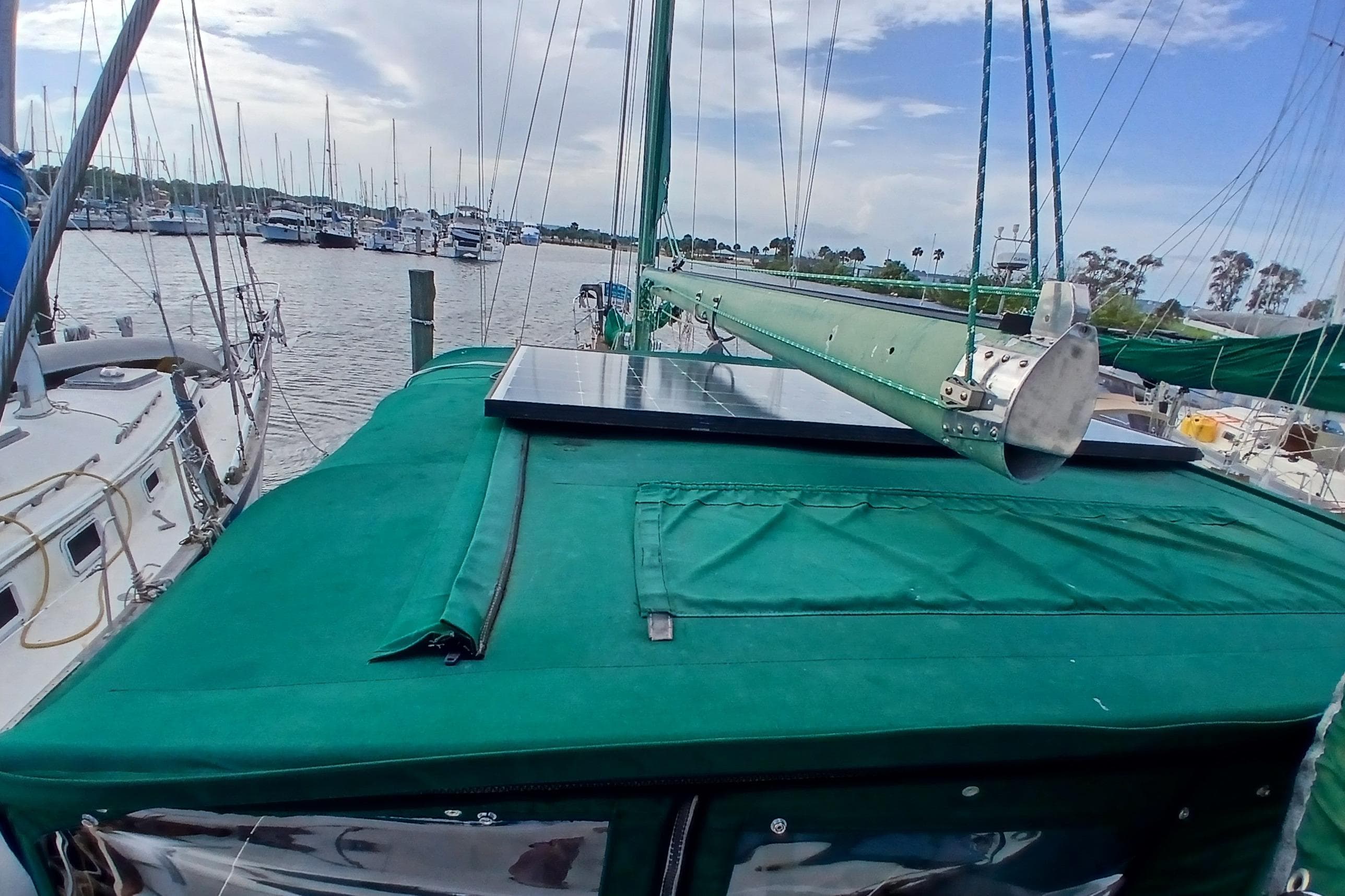 1981 Wellington 44 Center Cockpit sailboat with green cover and solar panel at marina.
