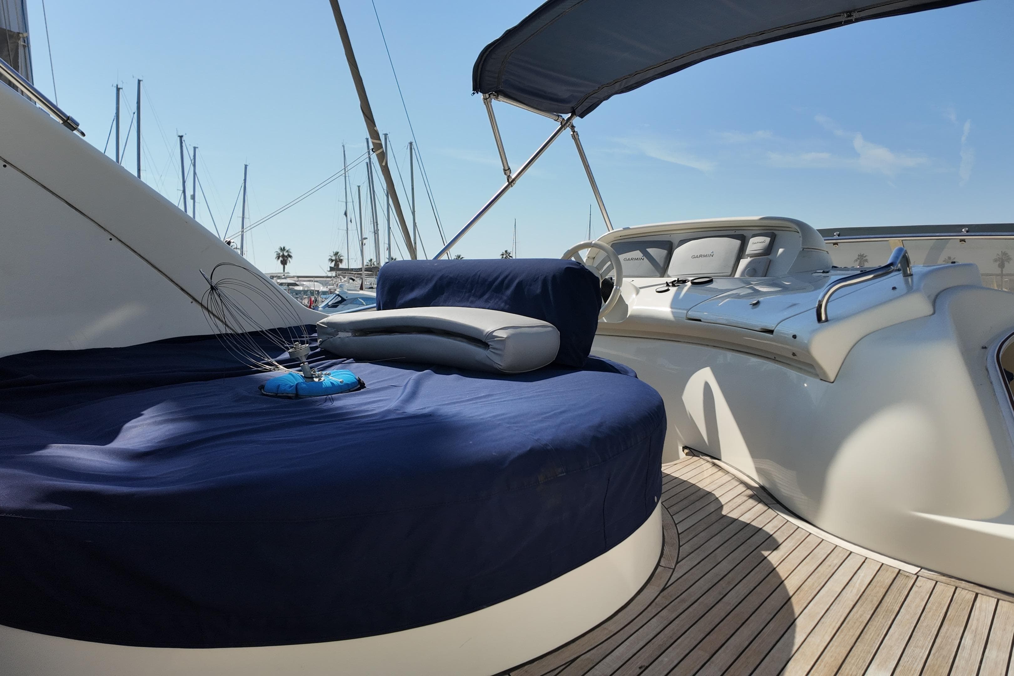 Luxurious 2006 Azimut 68E yacht deck with seating and helm, docked at marina.