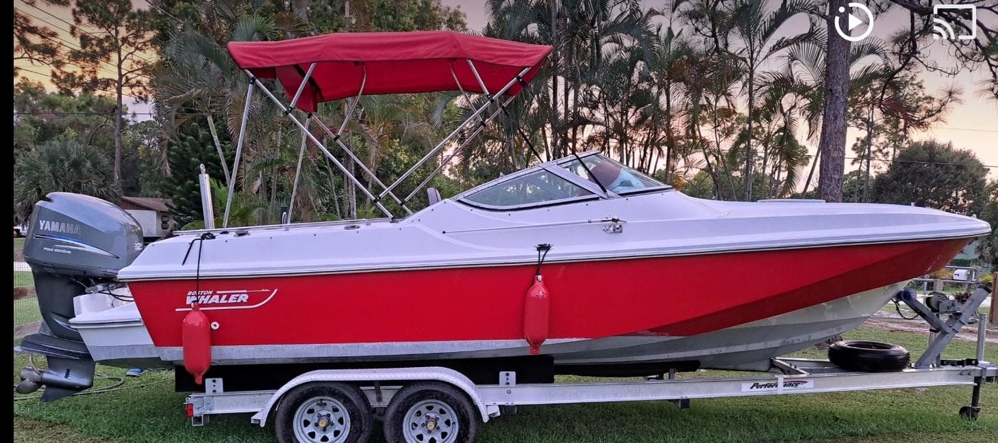1988 Boston Whaler Temptation 2200 boat with red hull on a trailer.