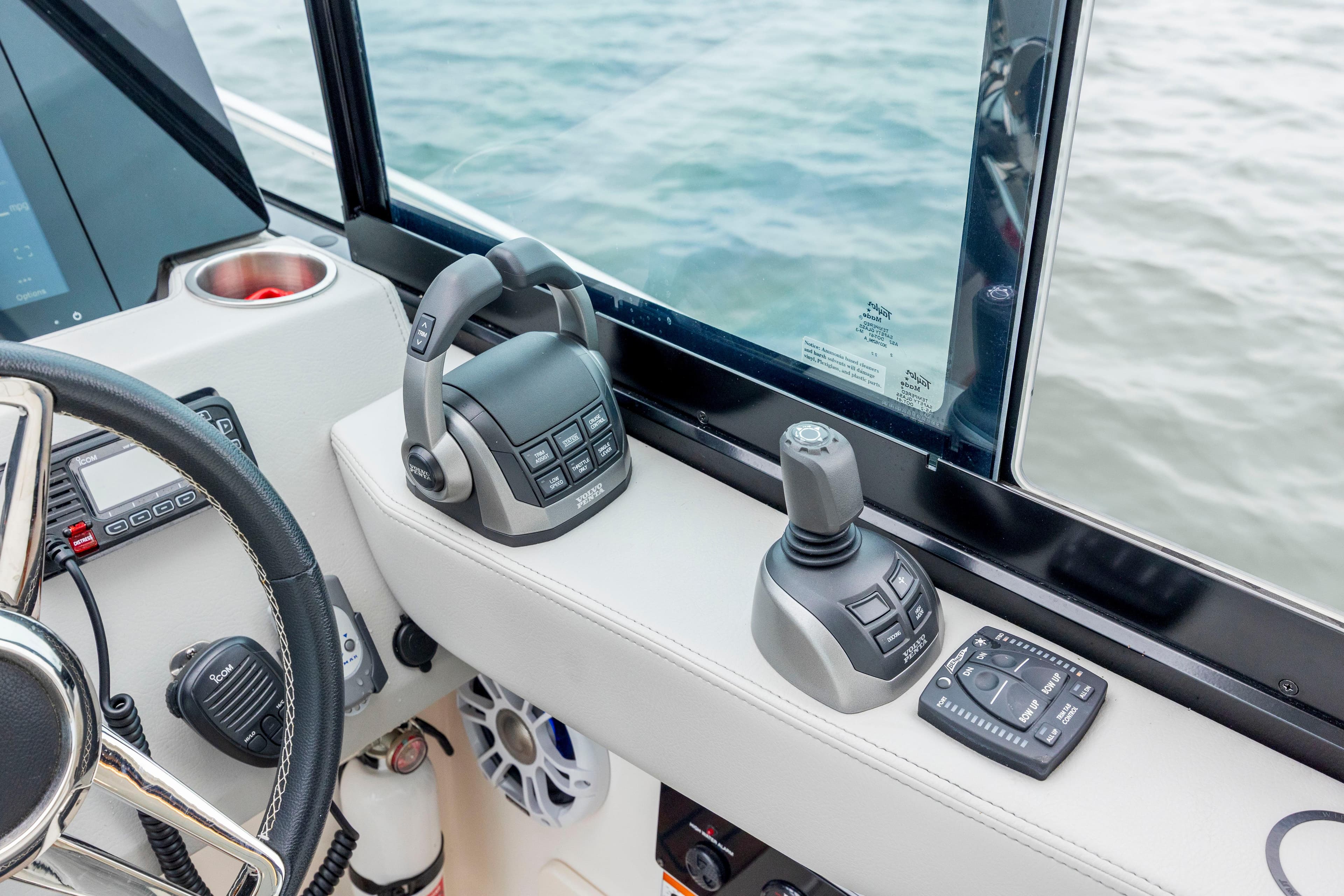 2022 Regal 36 Grande Coupe helm controls with joystick and throttle near water.