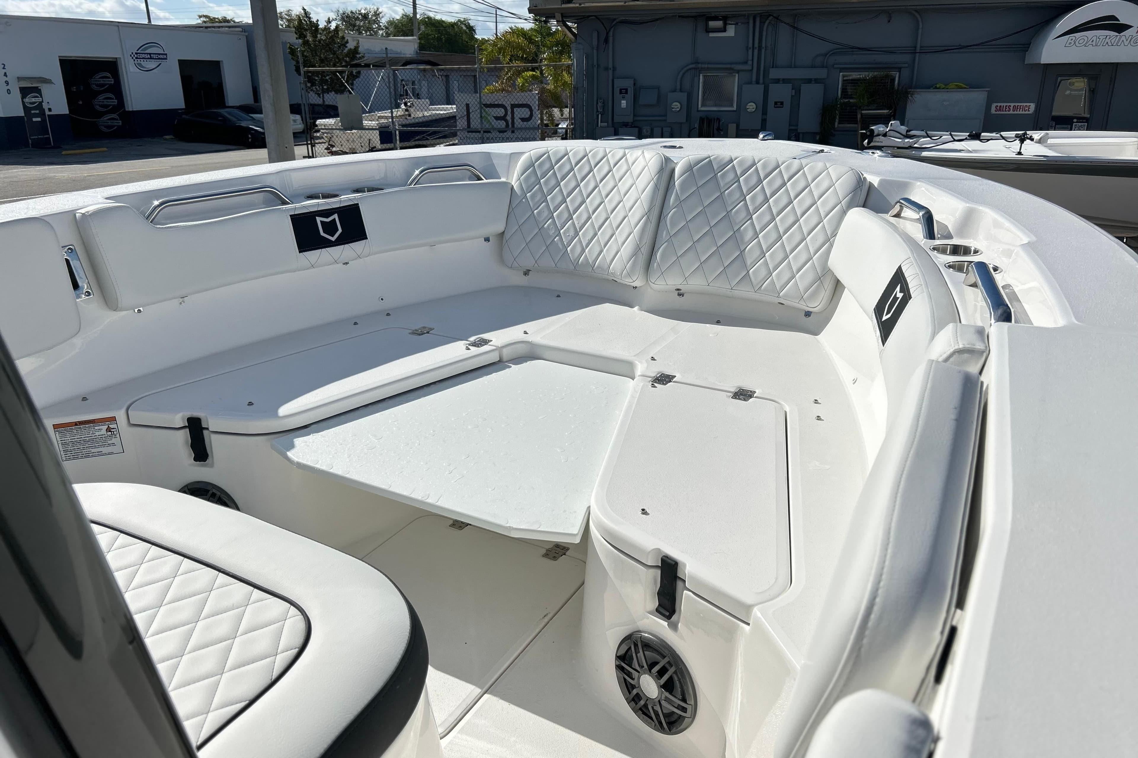 2026 Sea Fox 228 Commander boat interior with white cushioned seating and storage compartments.