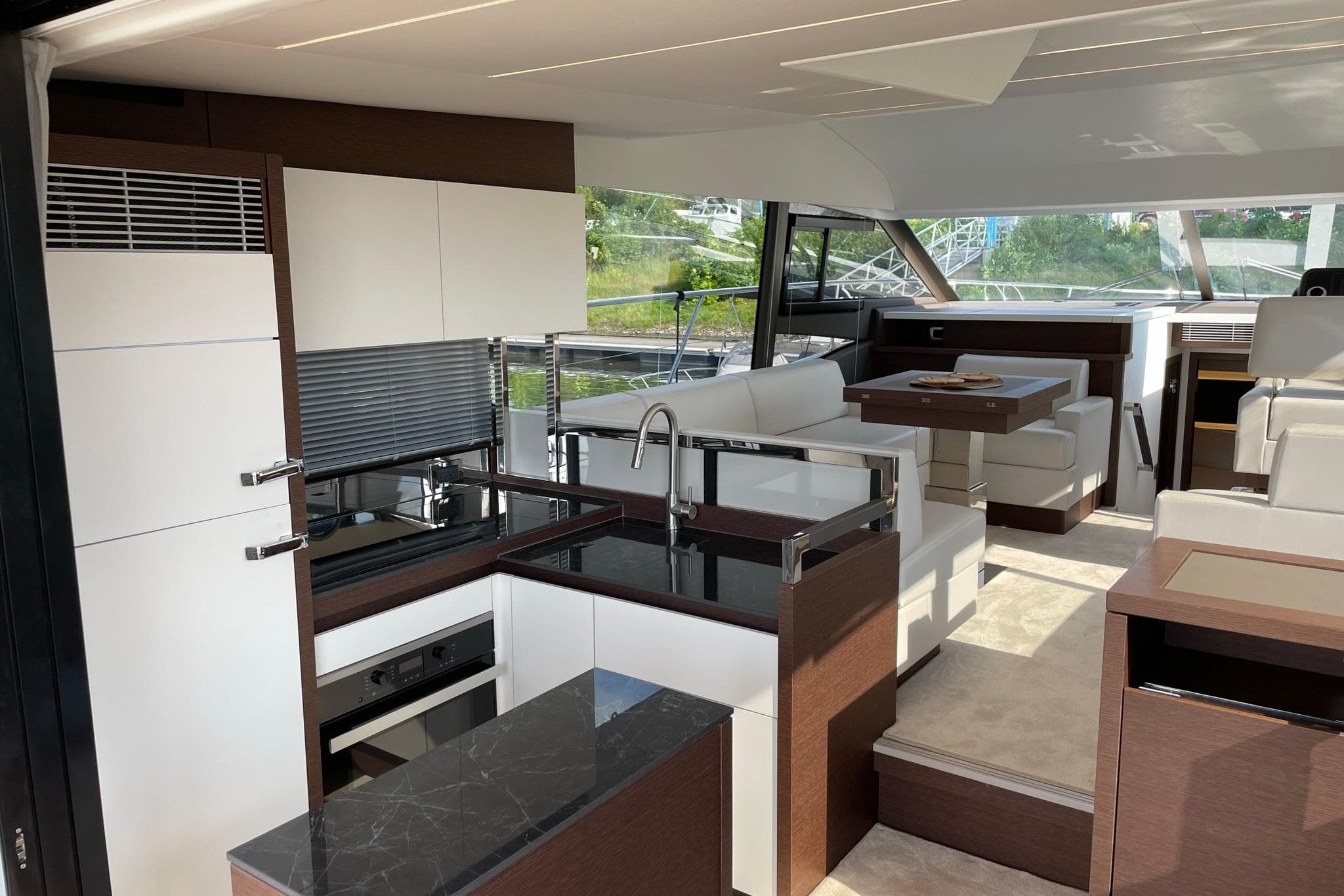 Luxurious interior of a 2022 Prestige 520 yacht with modern kitchen and seating area.