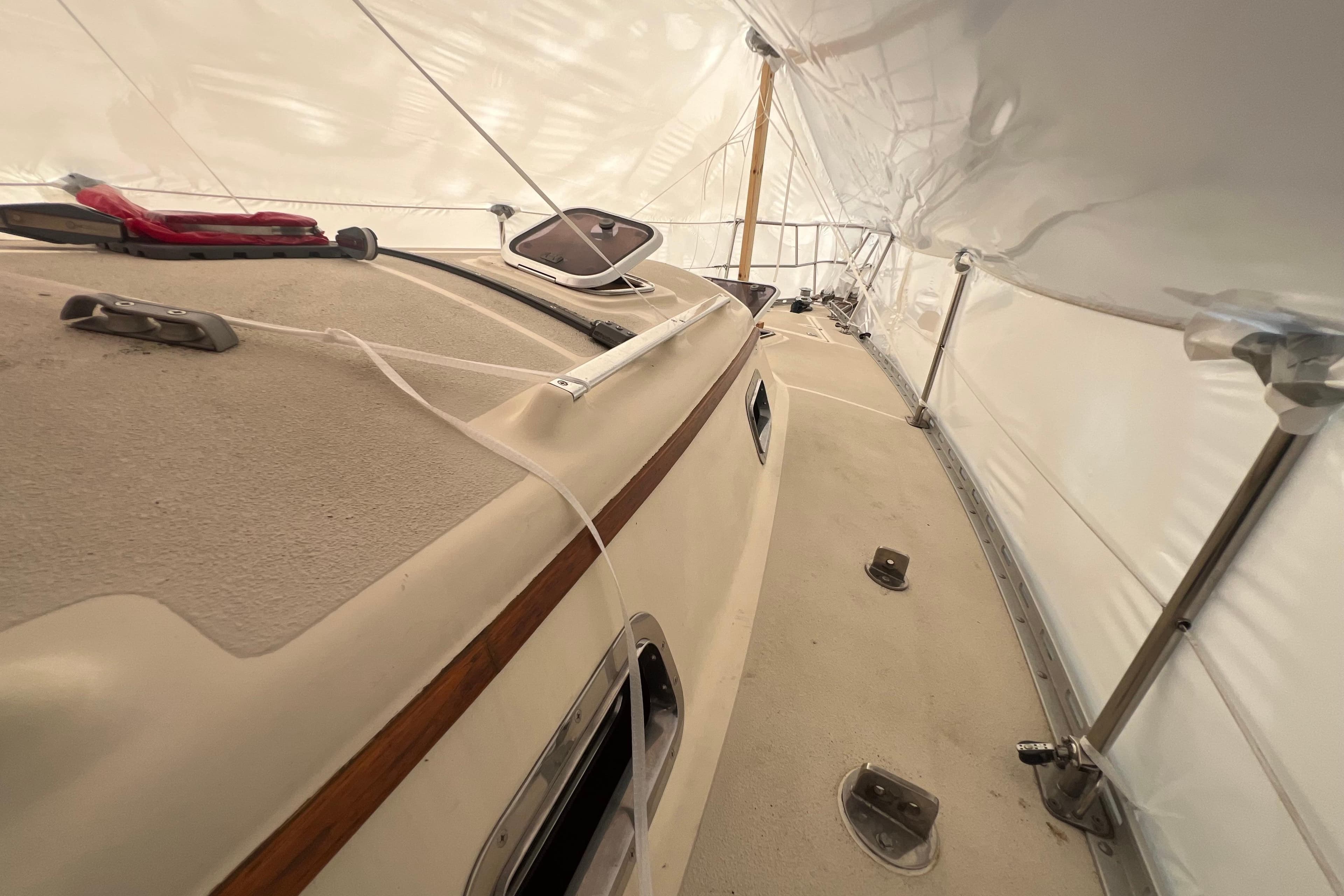 1996 Caliber 35 LRC sailboat deck under protective cover, showcasing rigging and fittings.