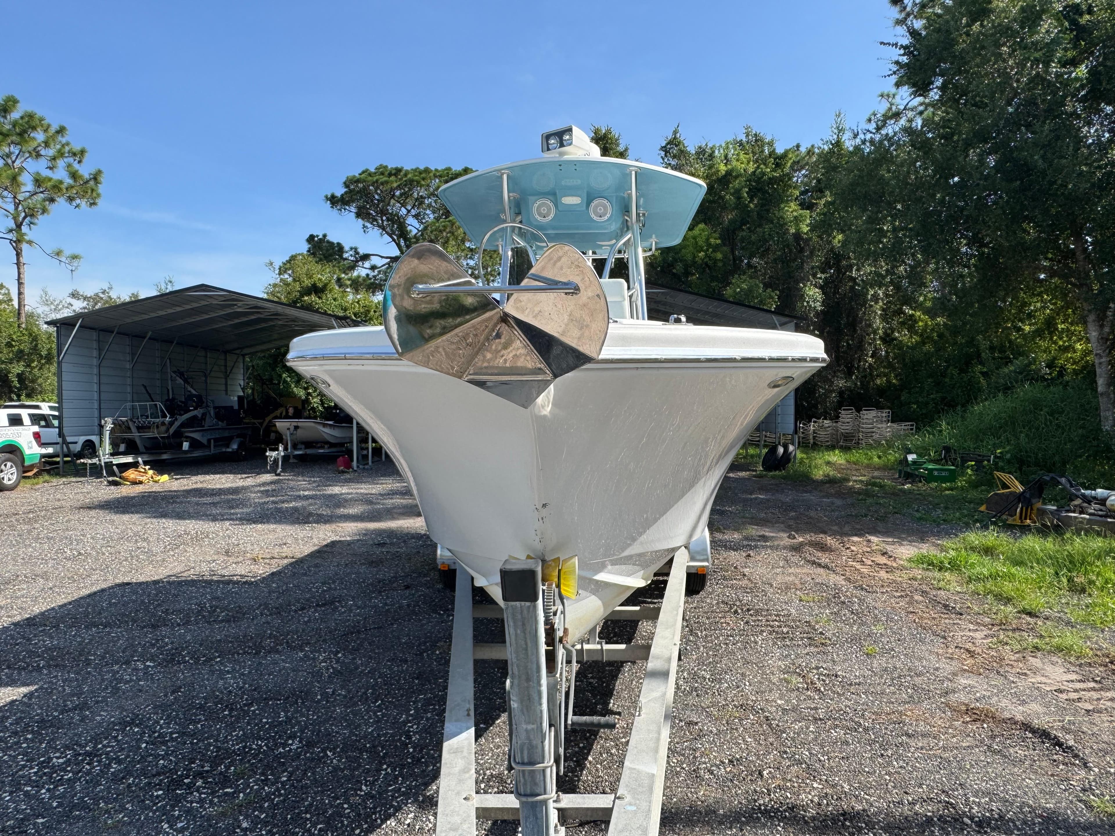 2012 Ocean Runner 290i boat on trailer, parked outdoors under clear sky.