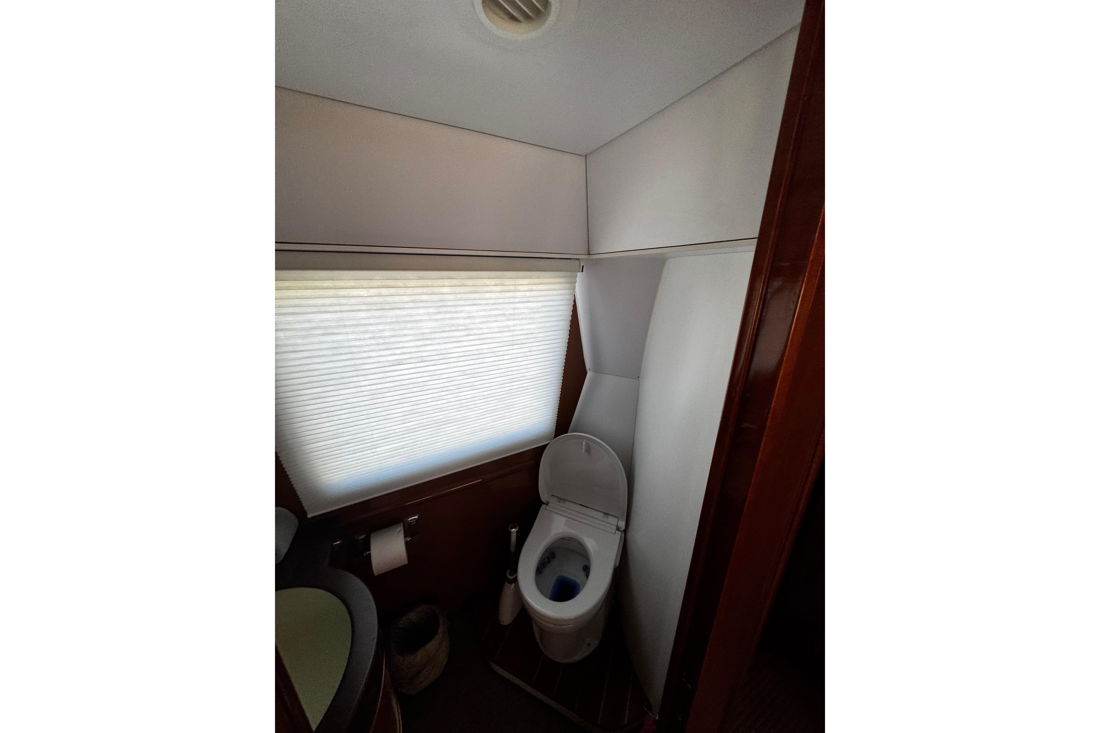 Bathroom interior of 1996 Hershine Benship 87 yacht with toilet and window blinds.