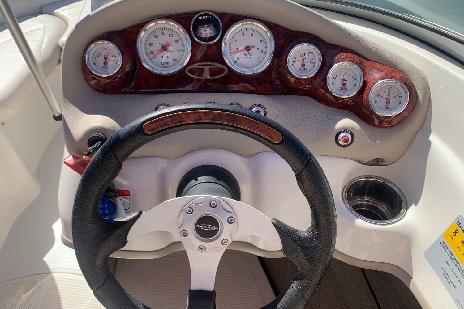Dashboard of a 2012 Tahoe Q5i boat with steering wheel and gauges.