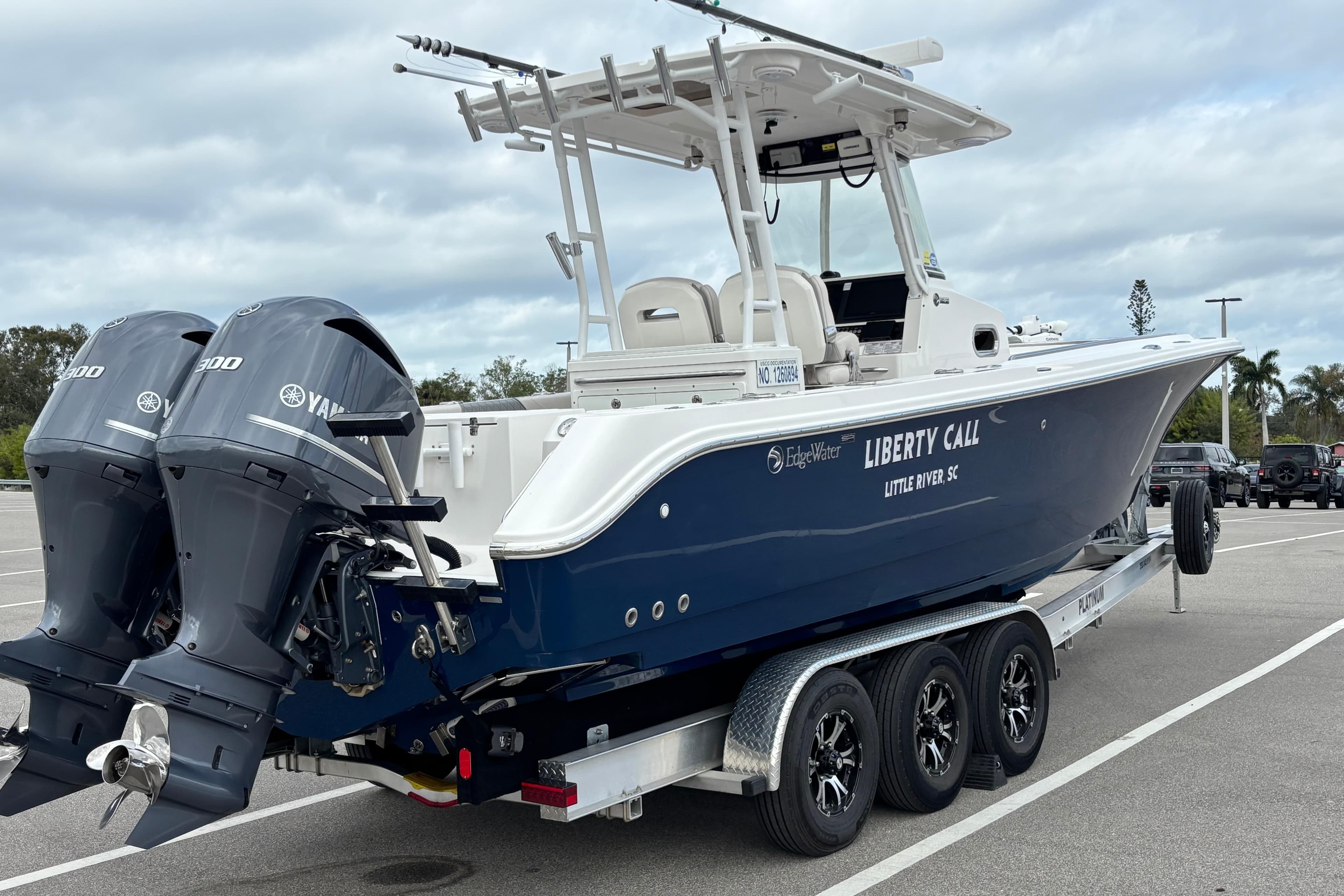 2015 Edgewater 320CC boat on trailer with twin Yamaha engines, parked in a lot.