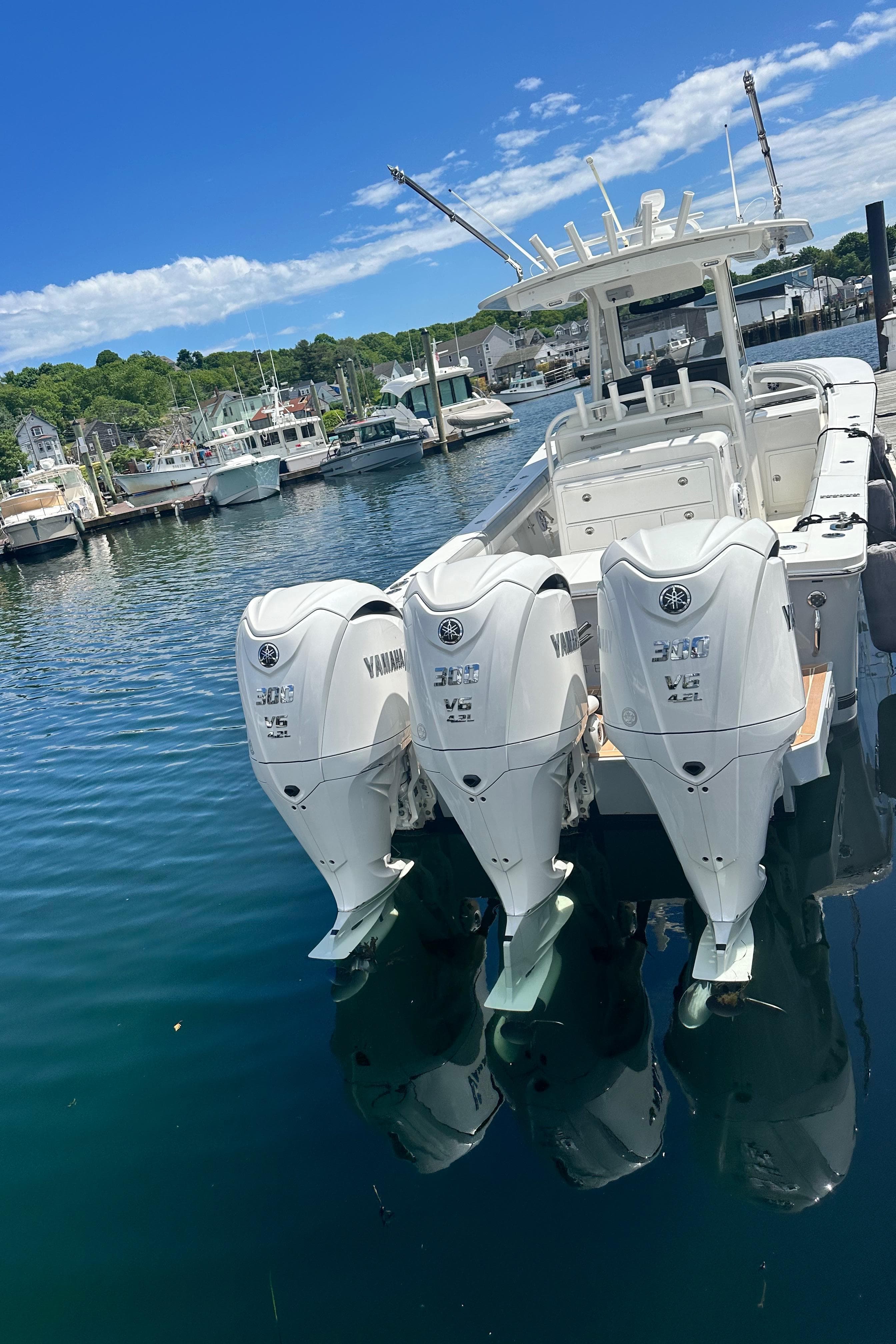 2022 Regulator 34 boat with triple Yamaha engines docked in a marina.