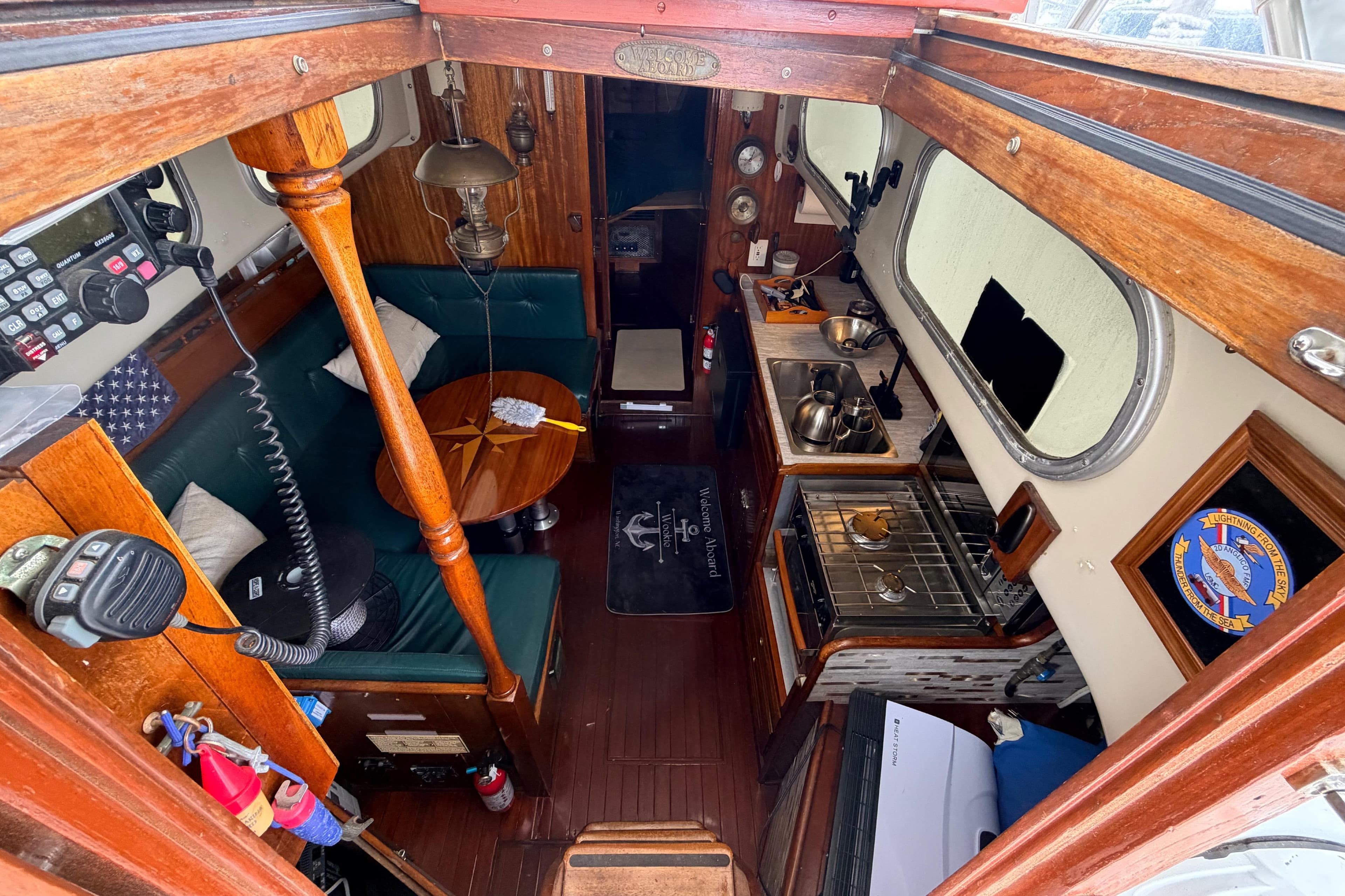 Interior of a 1964 Columbia 33 sailboat with wood finishes and compact kitchen.