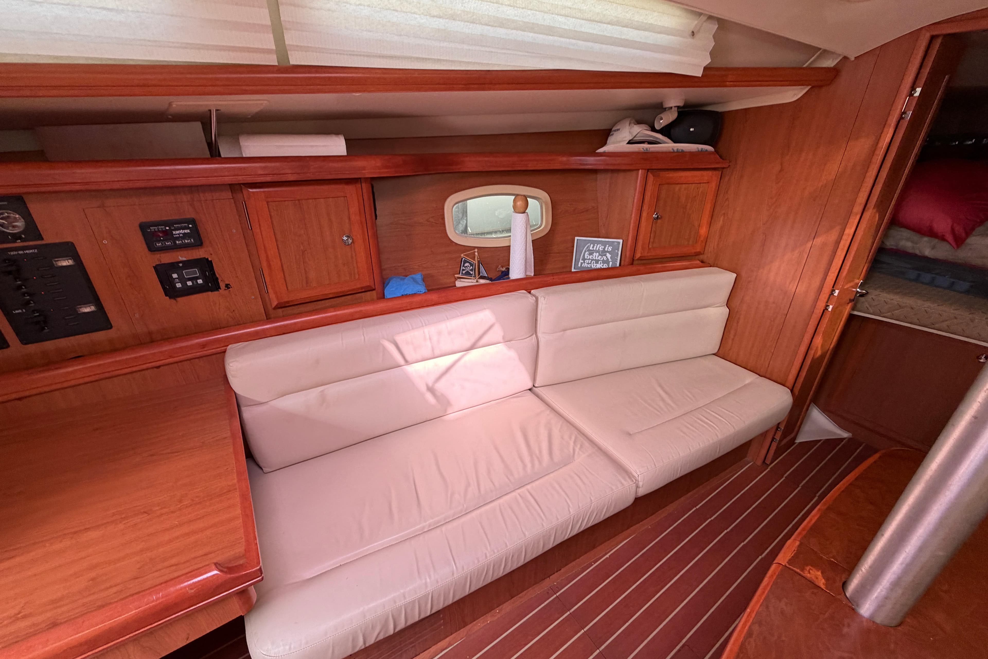 Interior of 2008 Hunter 36 sailboat with wooden cabinetry and white seating.