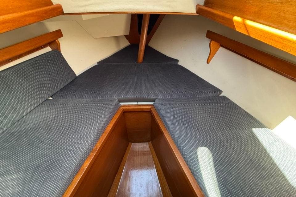 Interior of 1980 Rival 34 sailboat with wooden trim and cushioned seating.
