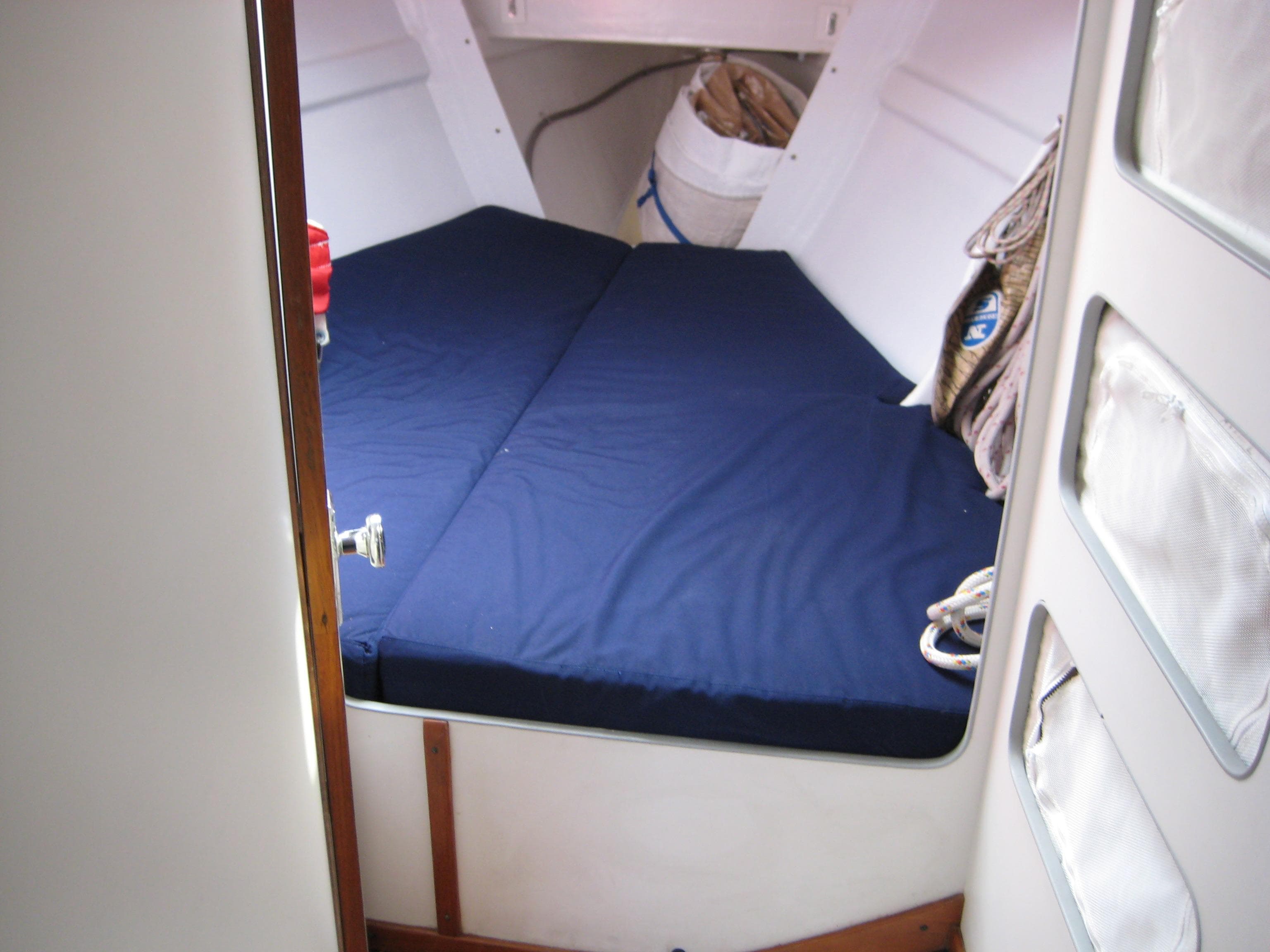 1991 J Boats J/39 cabin interior with blue bedding and storage compartments.