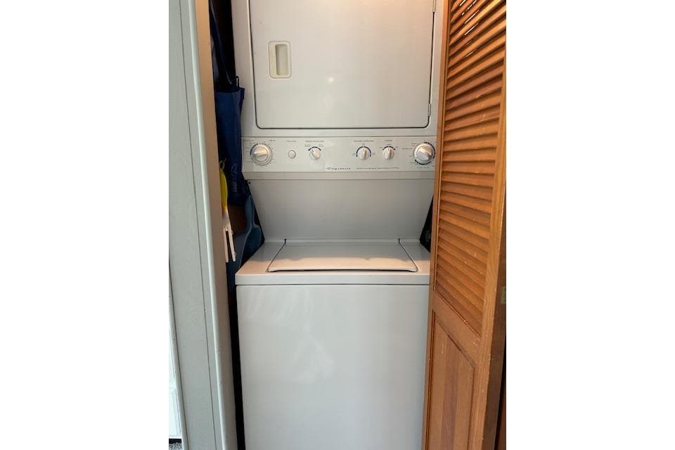 Stacked washer and dryer in 1987 Somerset Houseboat, model 14X60, with wooden louvered door.