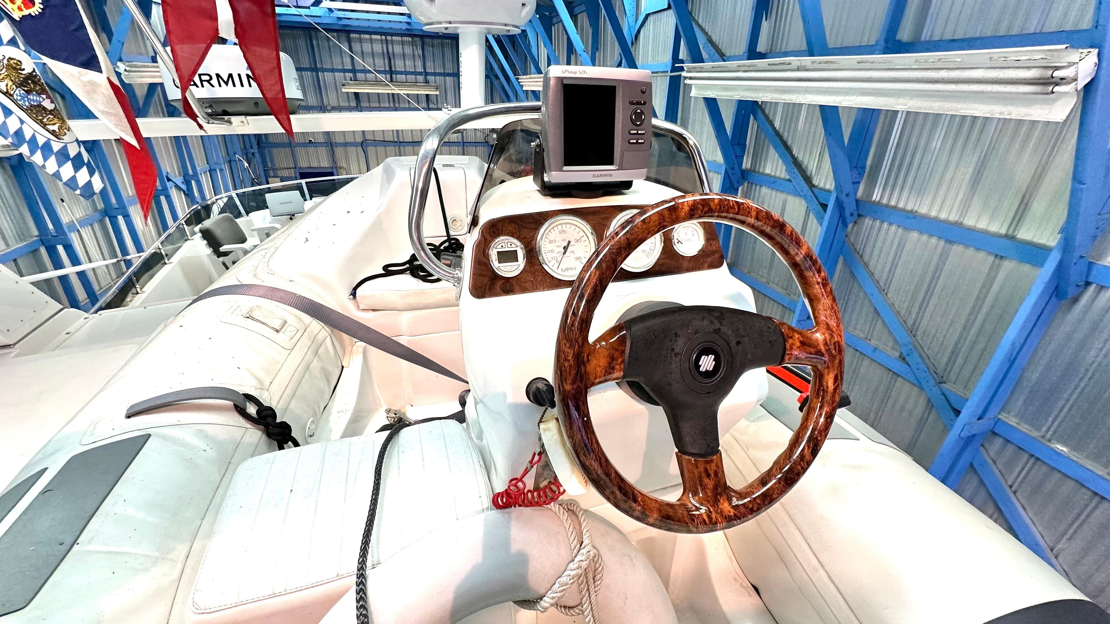 1991 Custom Trans World Del-Ray 53 boat cockpit with wooden steering wheel and navigation equipment.
