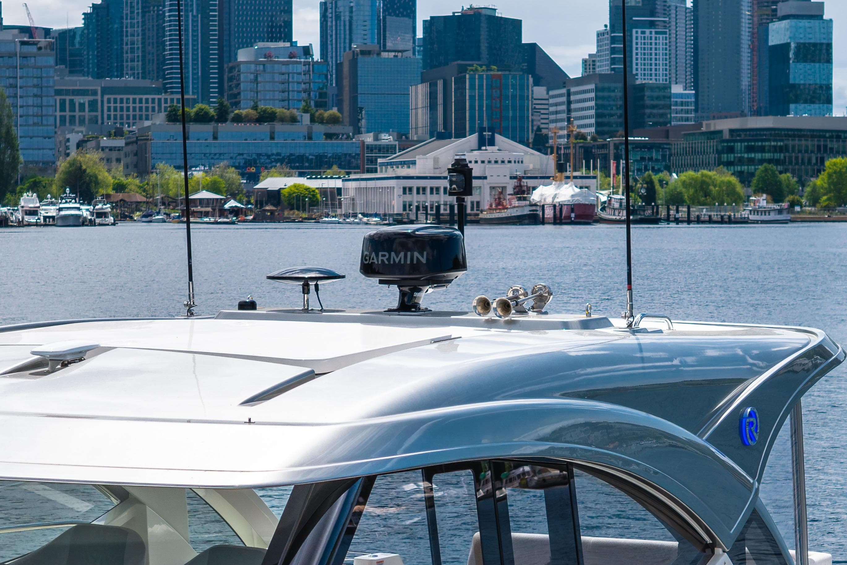 Riviera 4300 Sport Express 2026 yacht with city skyline in the background.