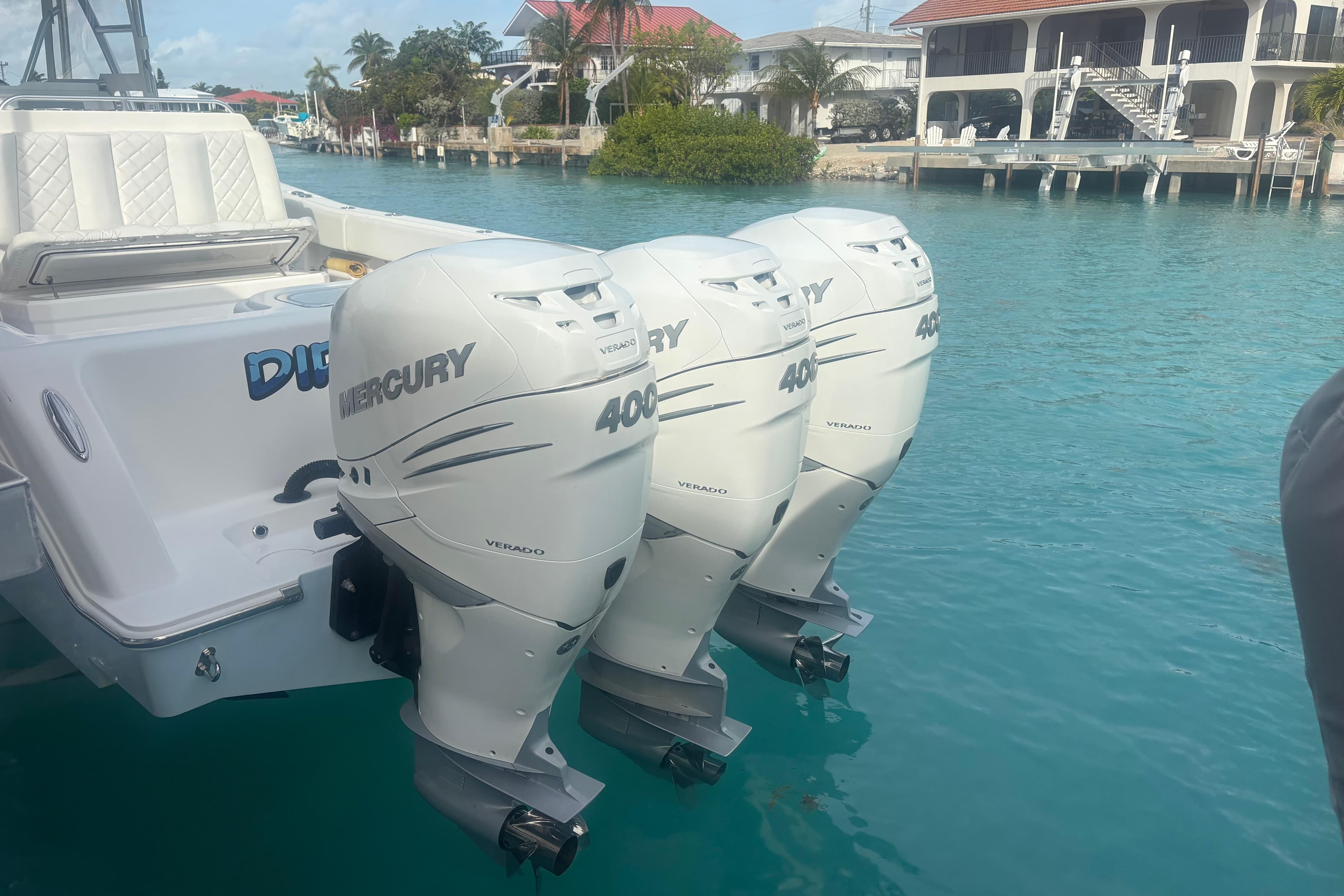 2017 Invincible 39 Open Fisherman with triple Mercury 400 outboard engines docked in turquoise water.