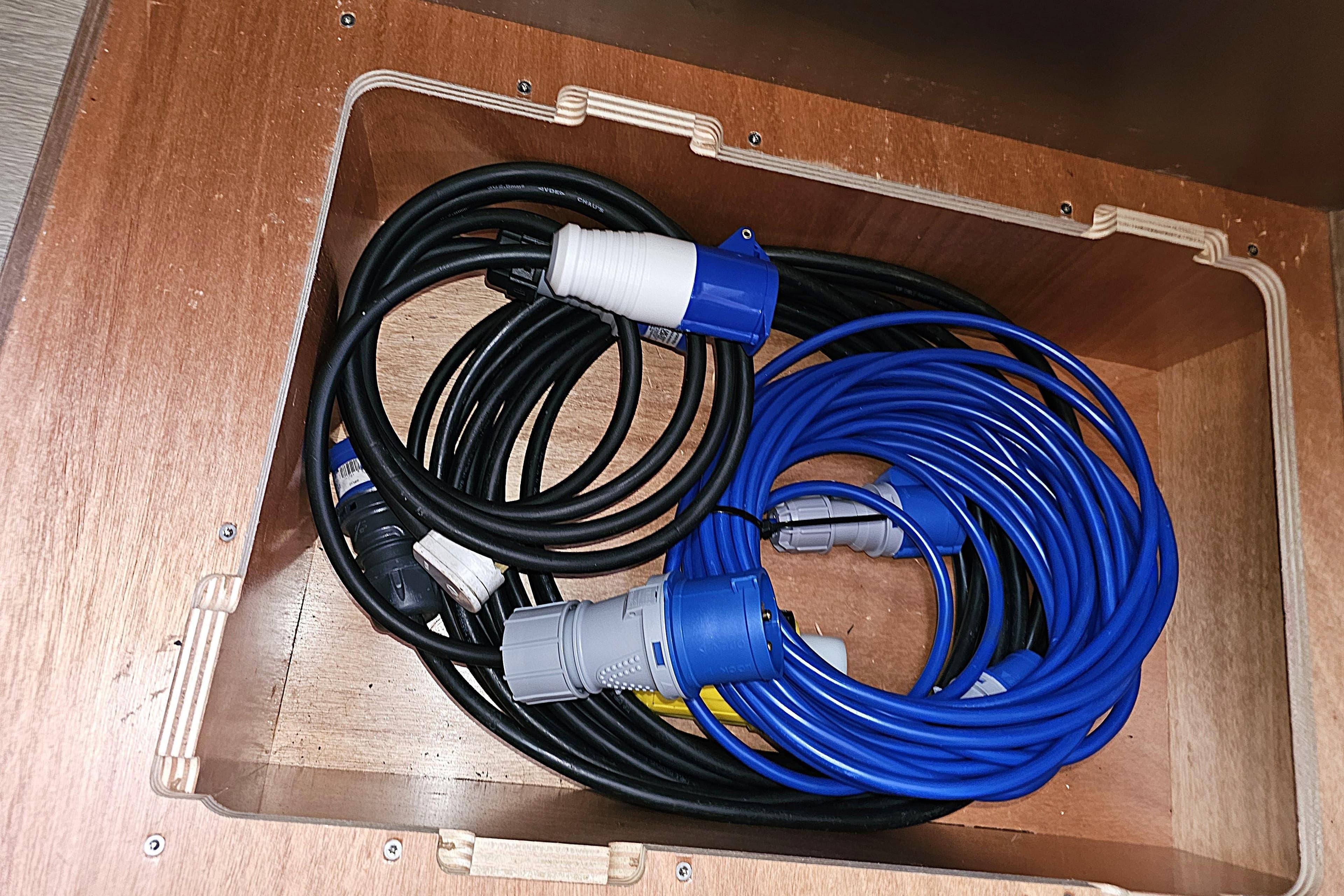 Coiled electrical cables in wooden compartment of 2018 Beneteau Swift Trawler 35.