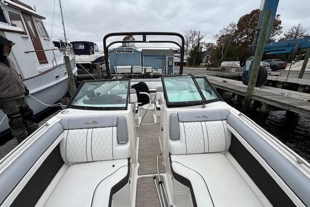 2016 Sea Ray 270 Sundeck boat interior with white seating at a marina.