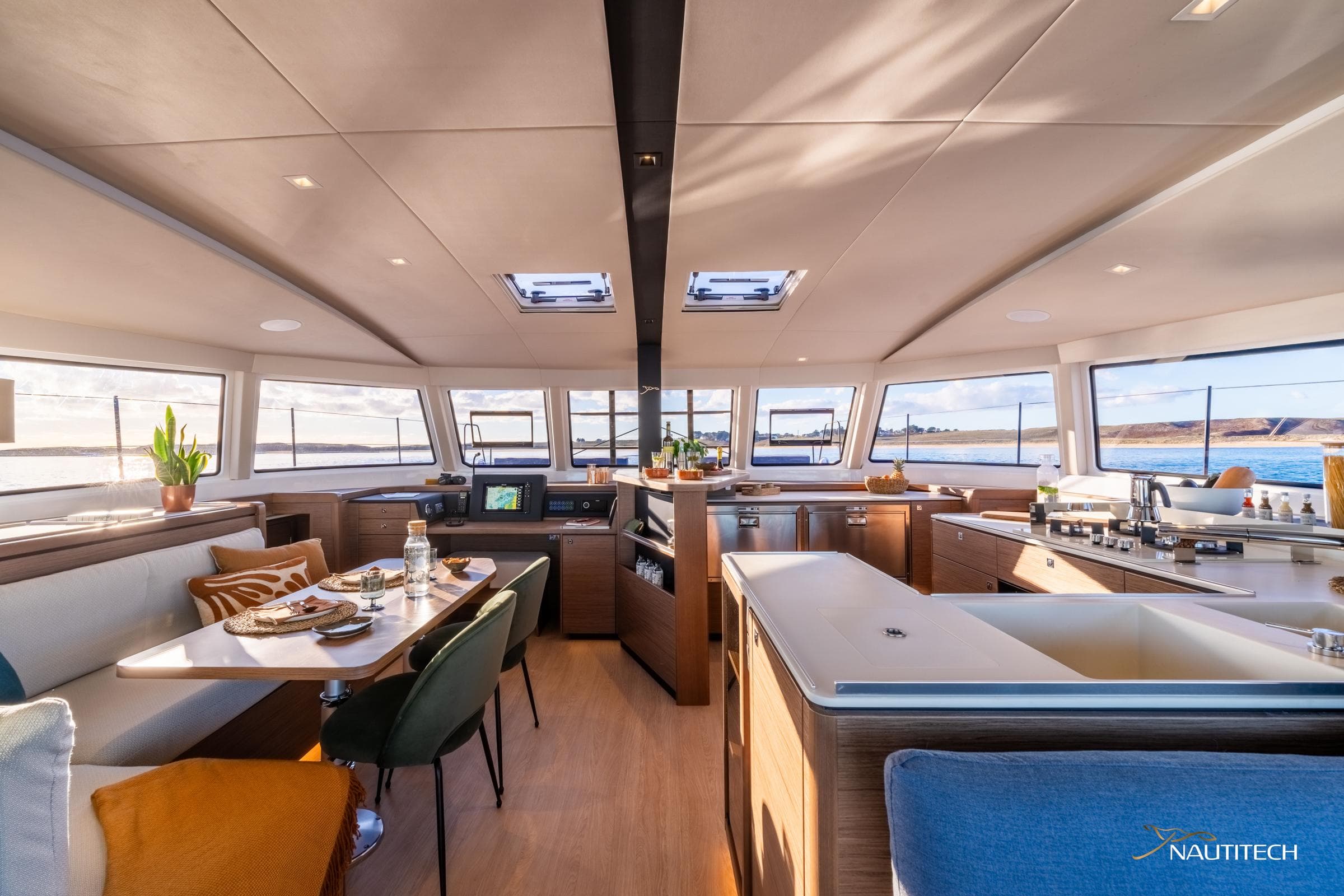 Luxurious interior of 2025 Nautitech 48 Open catamaran with modern dining and kitchen area.