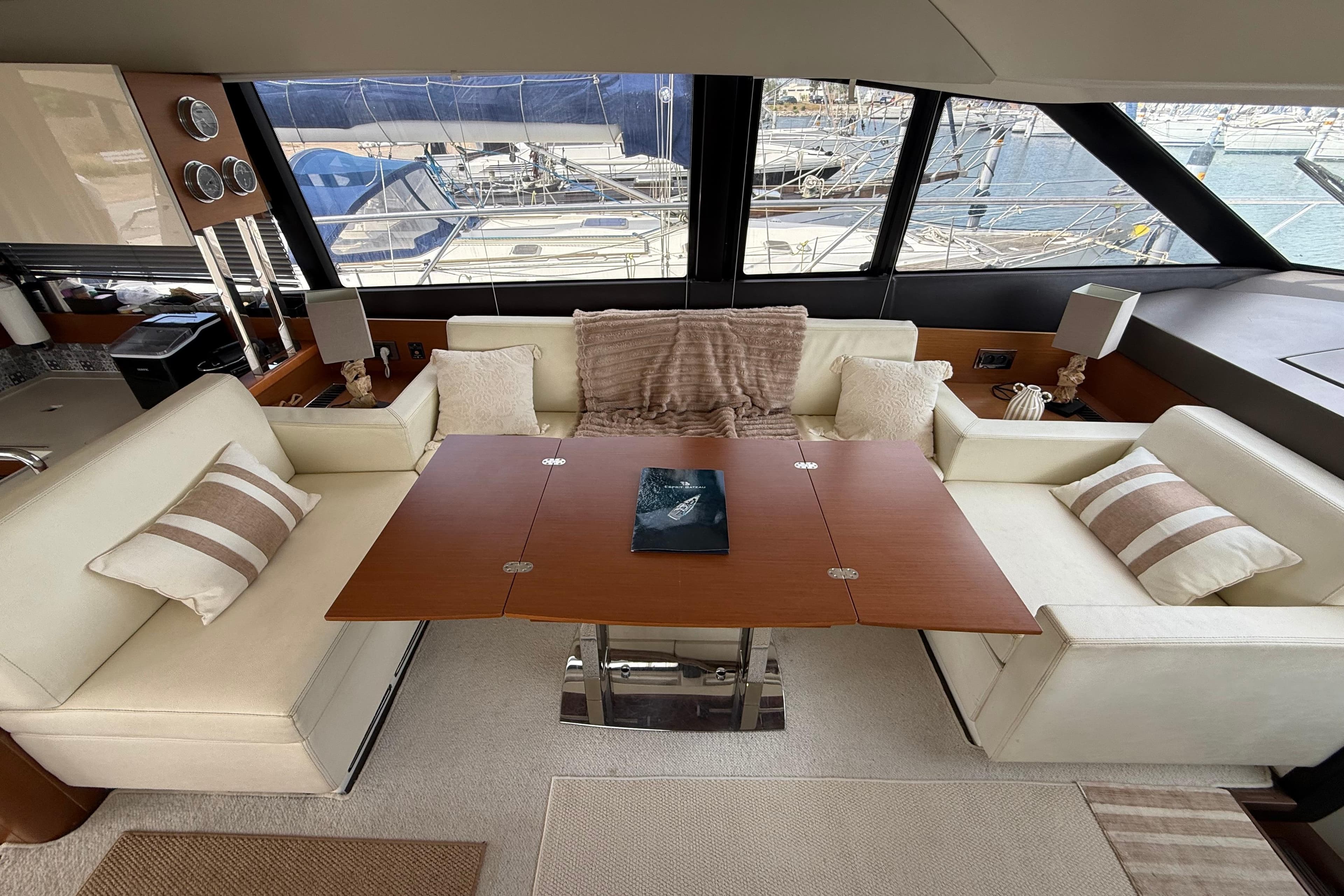 Luxurious interior of a 2012 Prestige 500 yacht with elegant seating and a wooden table.