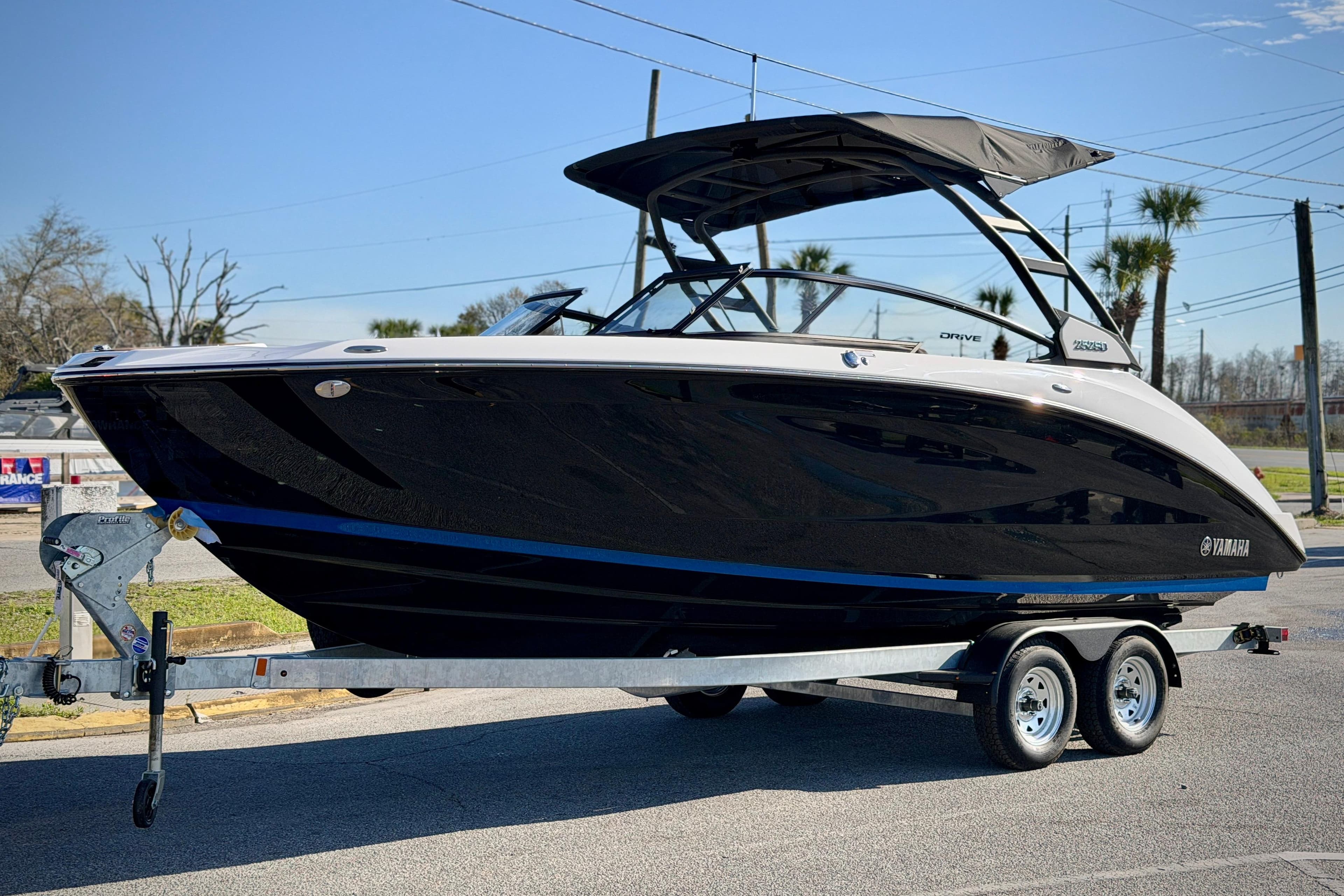 2026 Yamaha Boats 252SD on trailer, sleek black design, parked outdoors.
