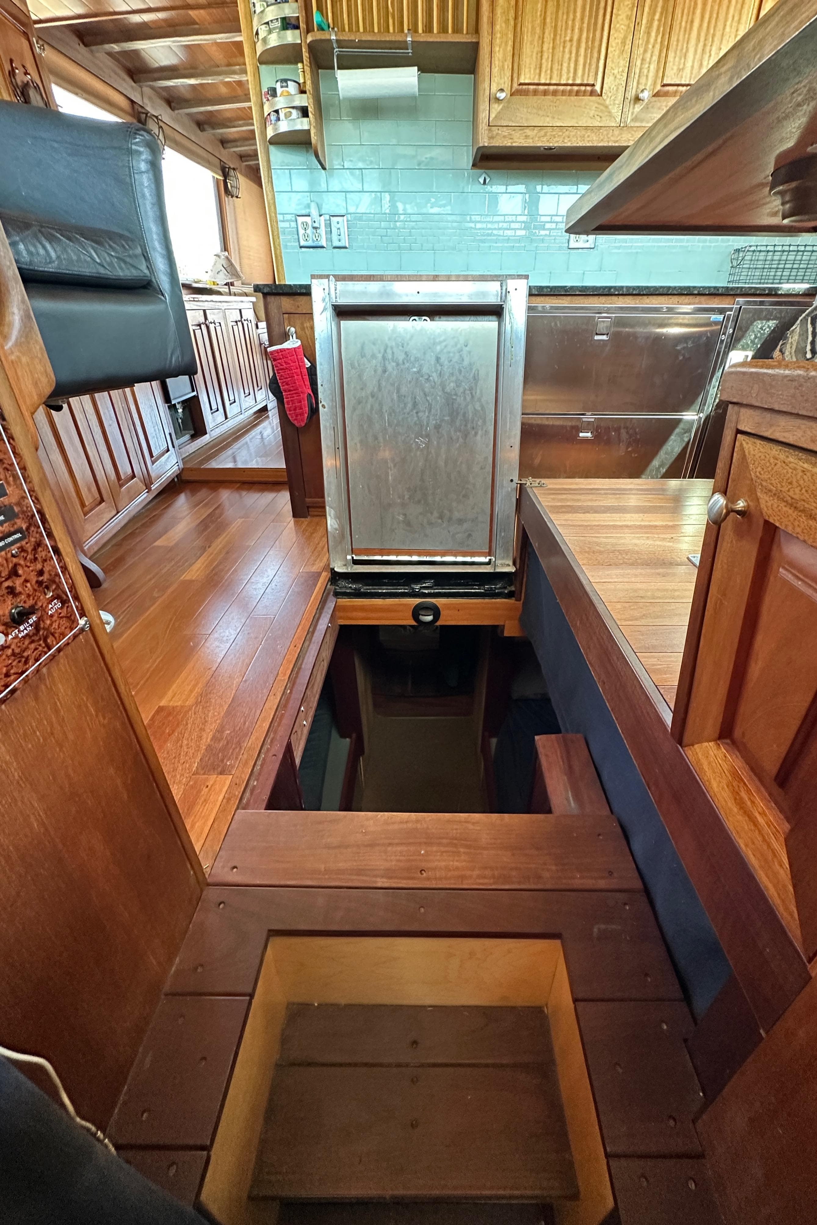 Interior of 2002 Carlson Marine Trawler with wooden cabinetry and stairs.