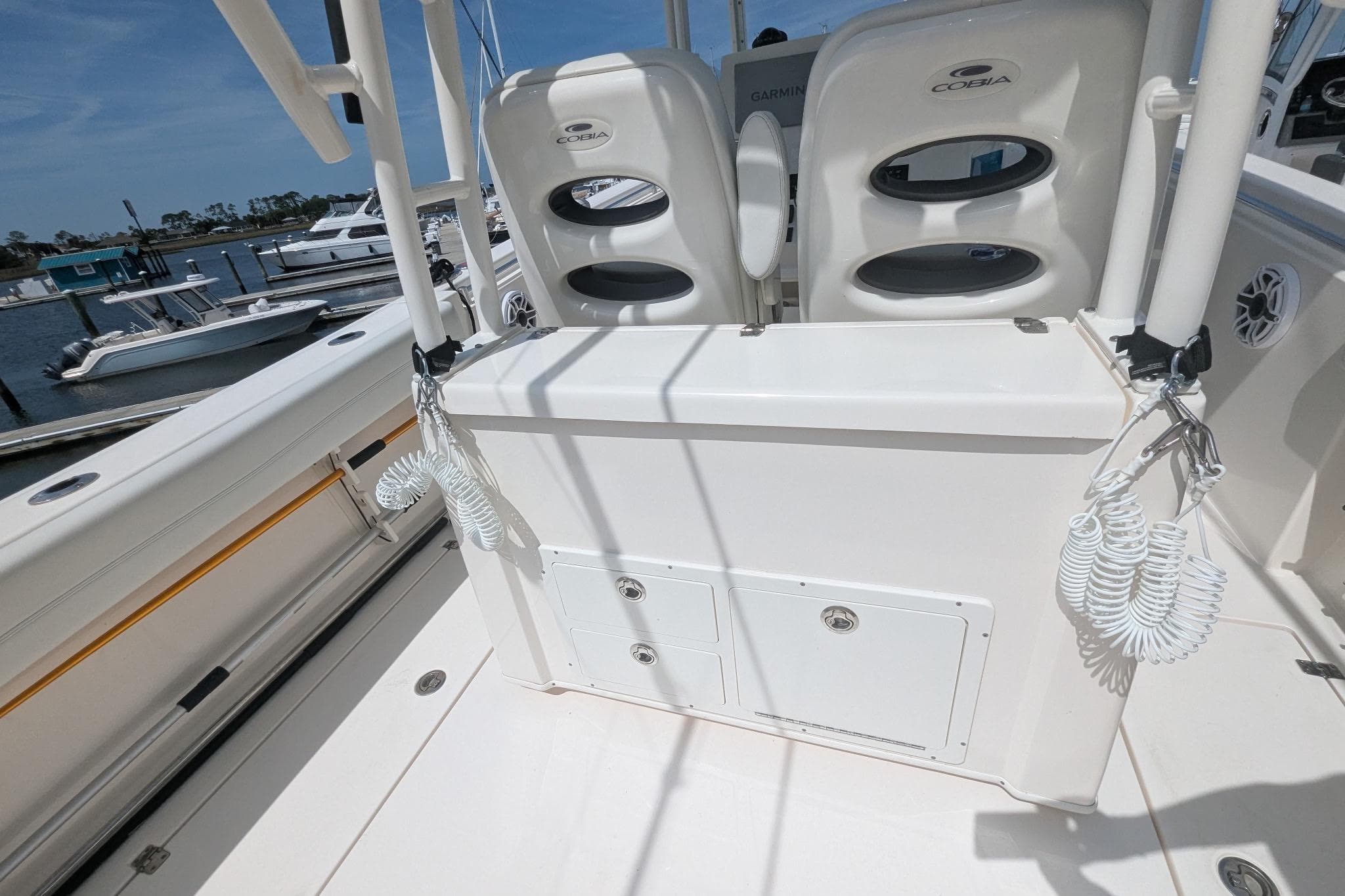 2023 Cobia 301 Center Console boat interior with seating and storage, docked at marina.