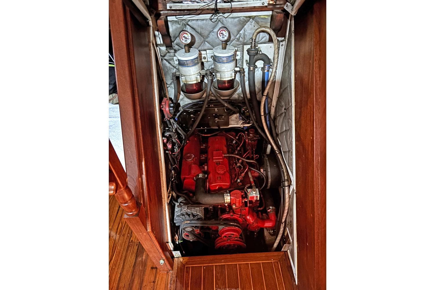 Engine compartment of 1993 Gozzard 44 MK1 AC sailboat, featuring red engine and gauges.