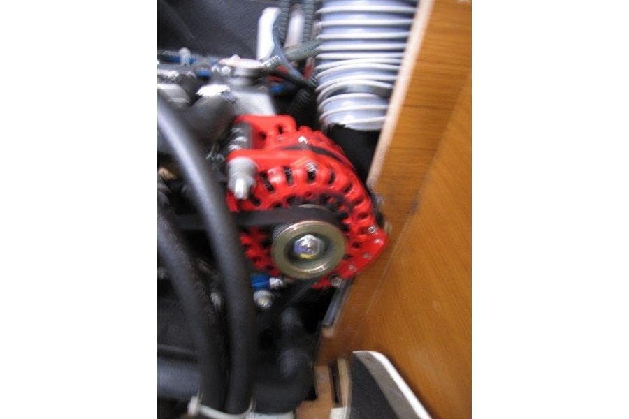 Engine component of 2022 Jeanneau Sun Odyssey 349 sailboat, featuring a red alternator.