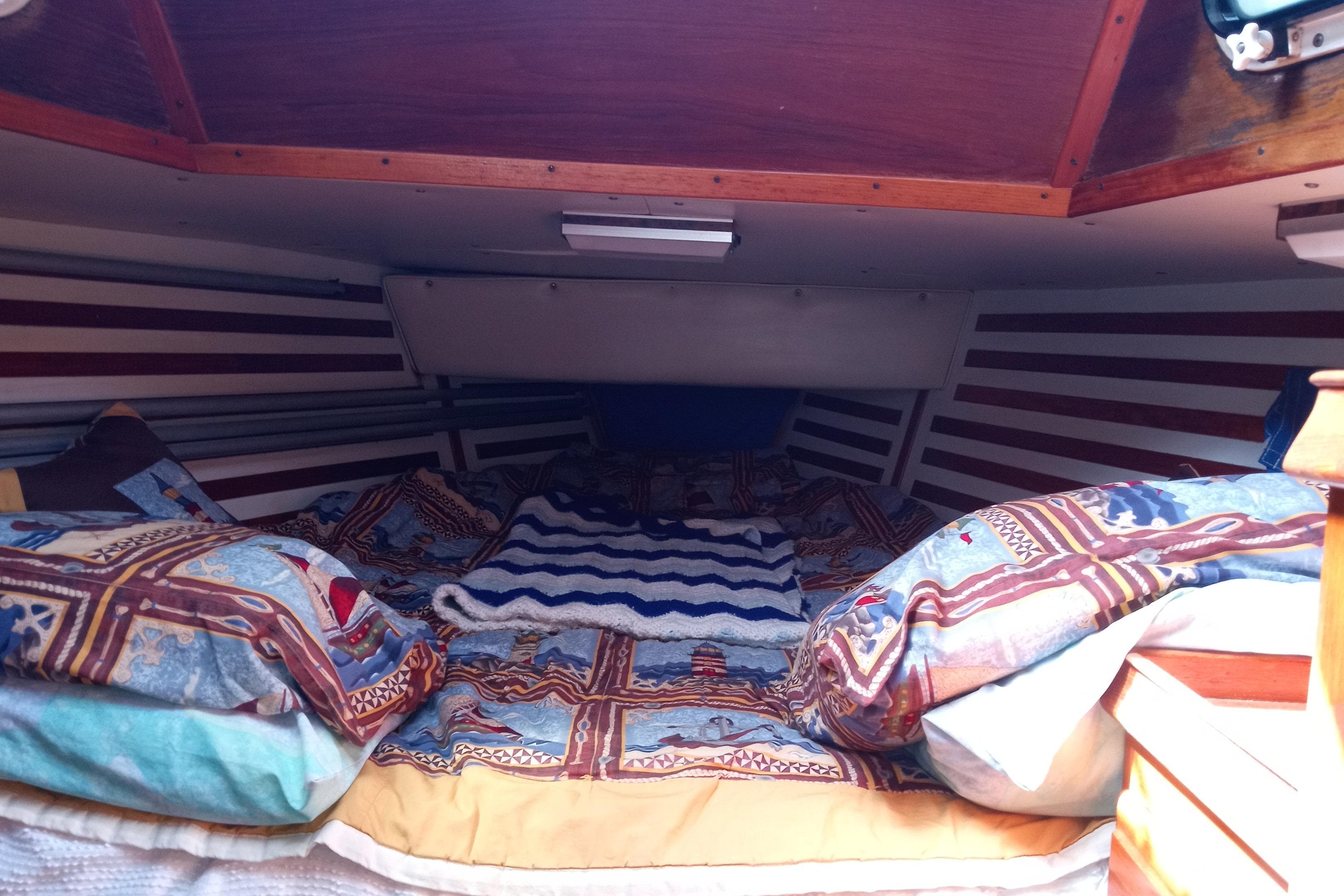 Cozy cabin interior of 1982 ENDEAVOR E37 sailboat with patterned bedding.