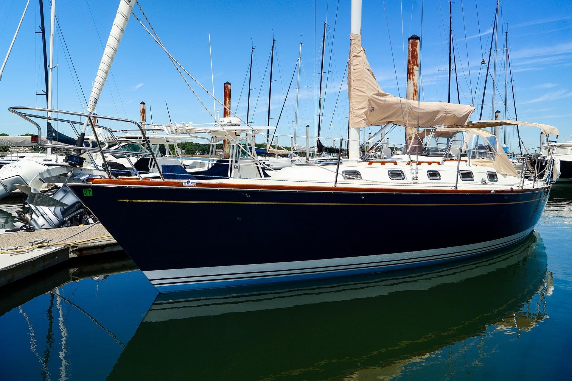 Sailboat docked at marina, Tartan 3500 model, 1999, with blue hull and beige covers.