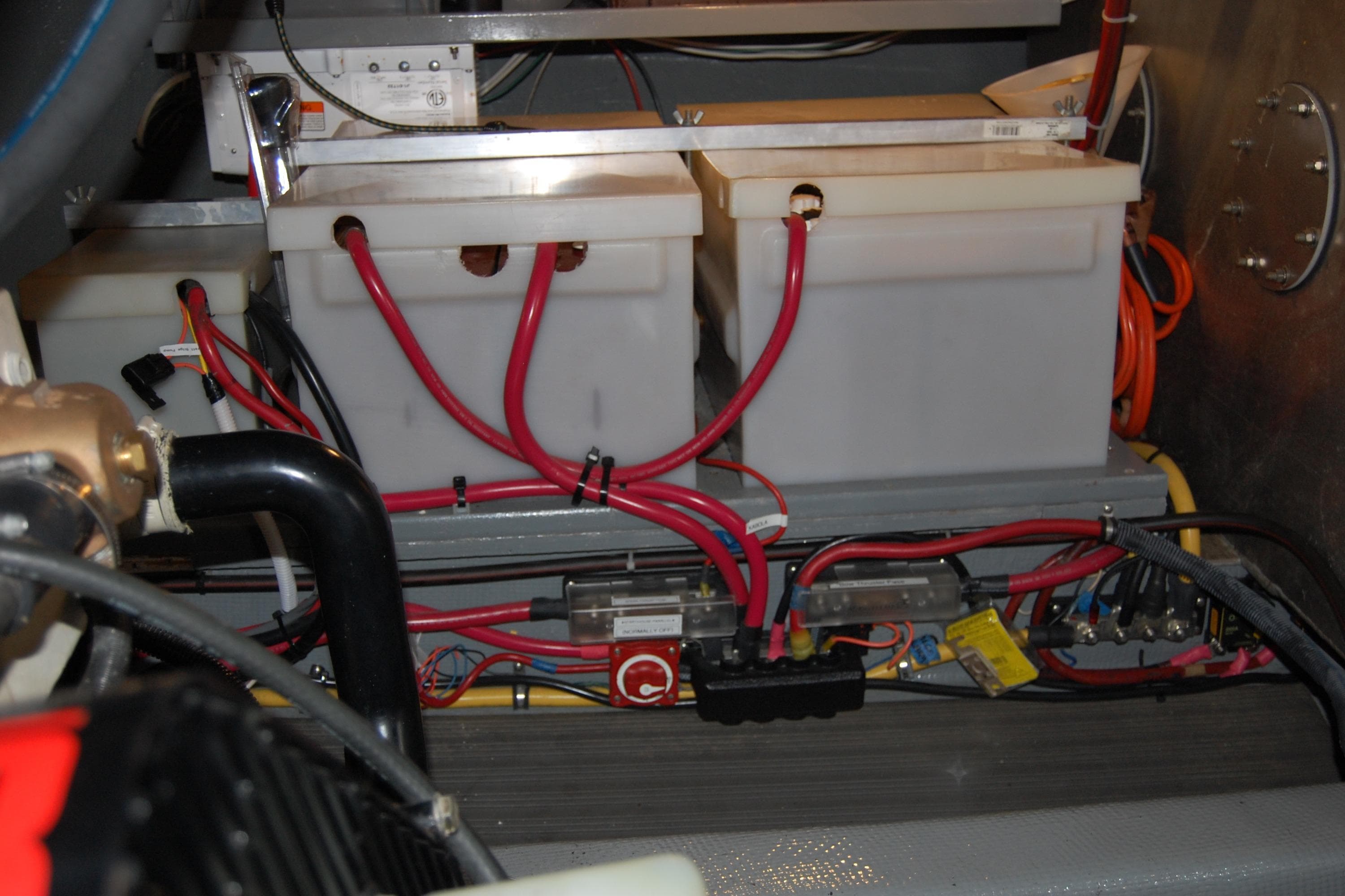 Engine room of 1981 Willard Marine Pilot House Trawler with battery setup and wiring.