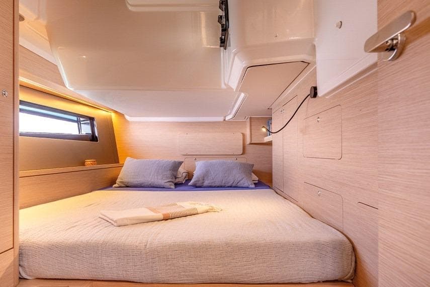 Luxurious cabin interior of 2025 Dufour 48 yacht with cozy bedding.