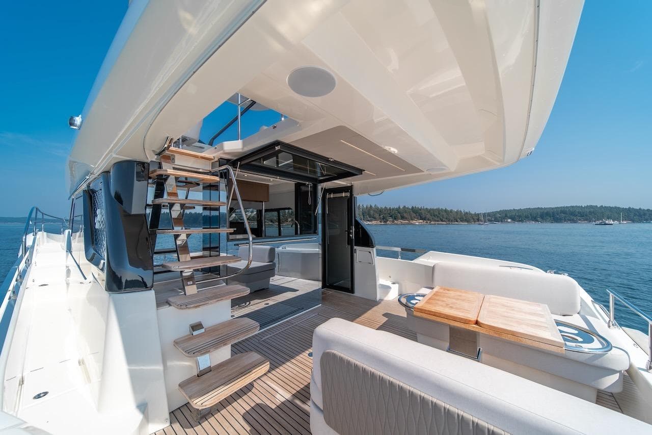 Luxurious 2025 Prestige F4.9 yacht deck with seating, table, and ocean view.